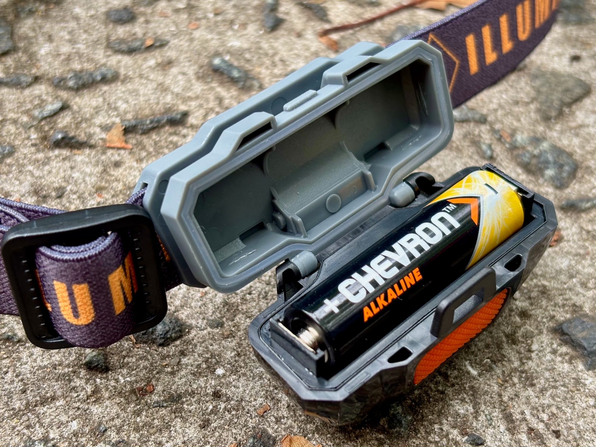 The battery compartment of the Kings Illuminator head torch open with an AA battery
