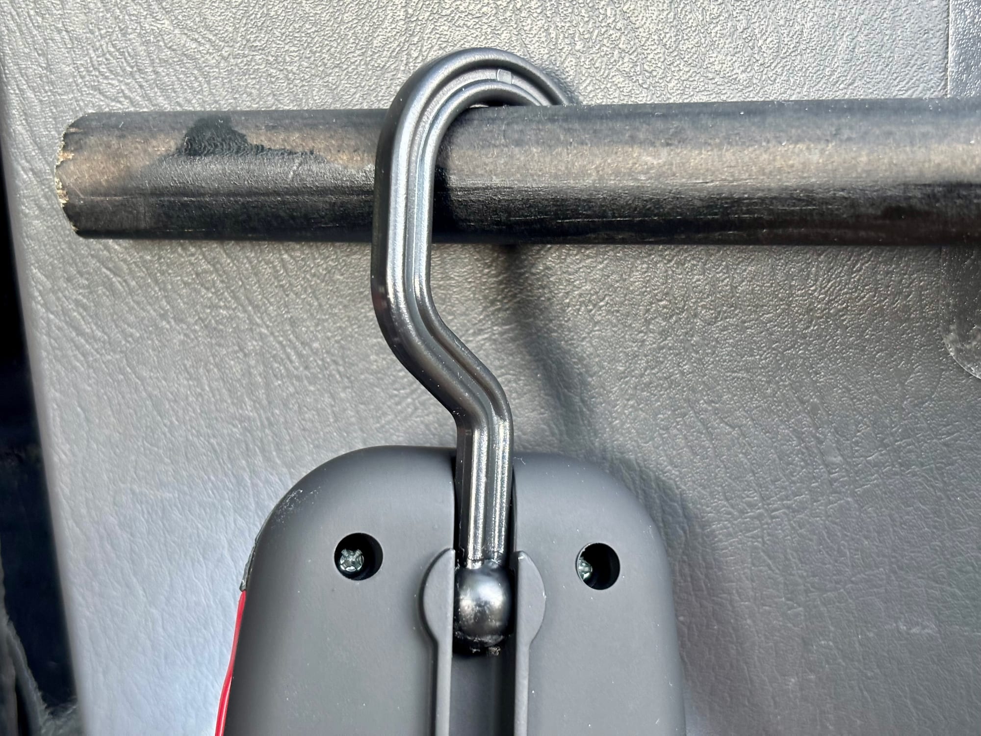 The hook of the Adventure Kings Illuminator LED work light hanging over a bar