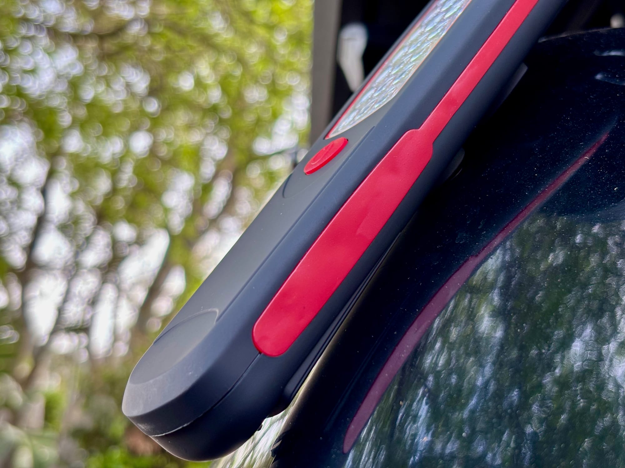 The Adventure Kings Illuminator LED work light held on the side of the car by its magnet