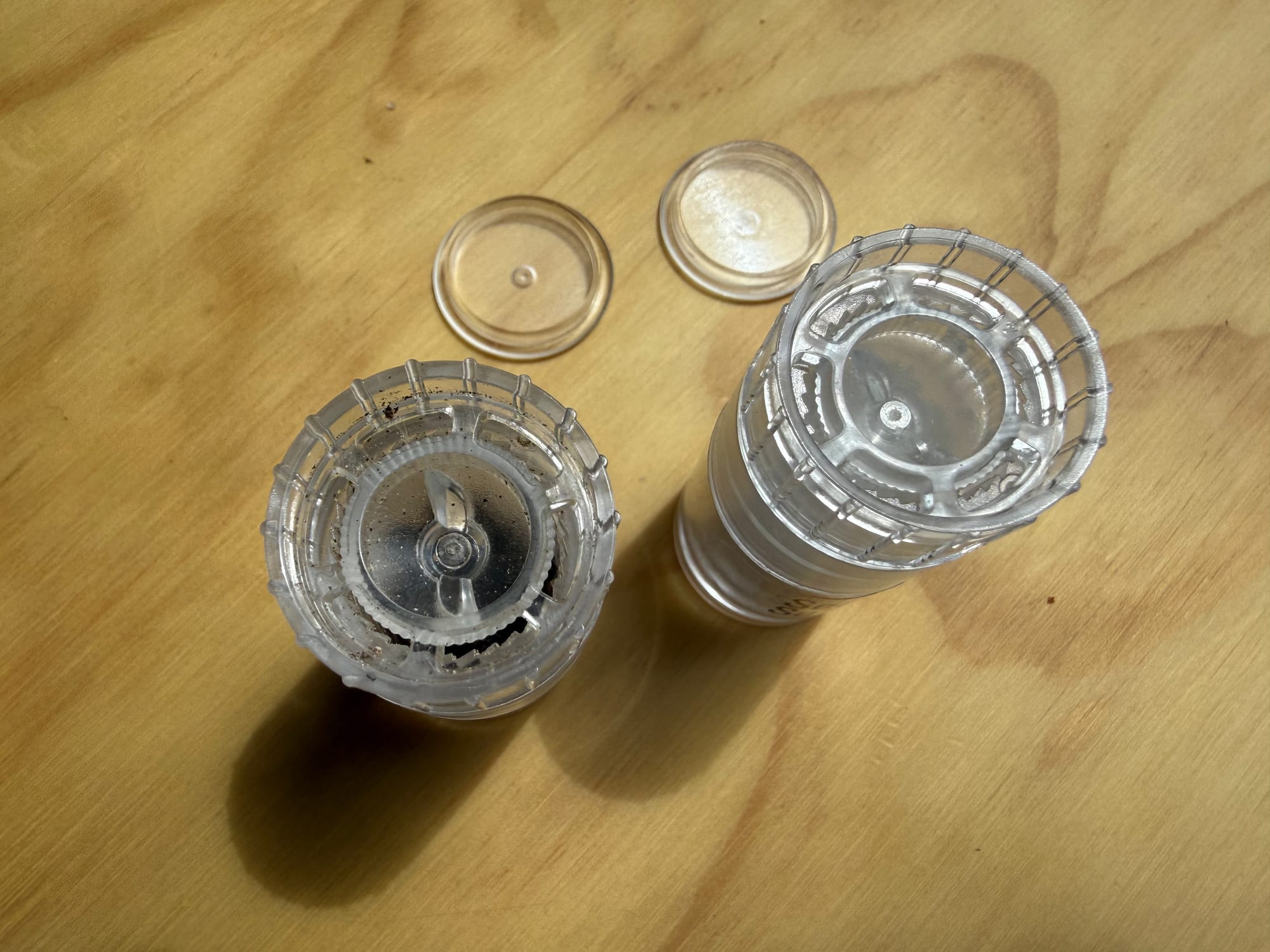 The two AGS mini grinders from above with their caps off, showing the grinder heads