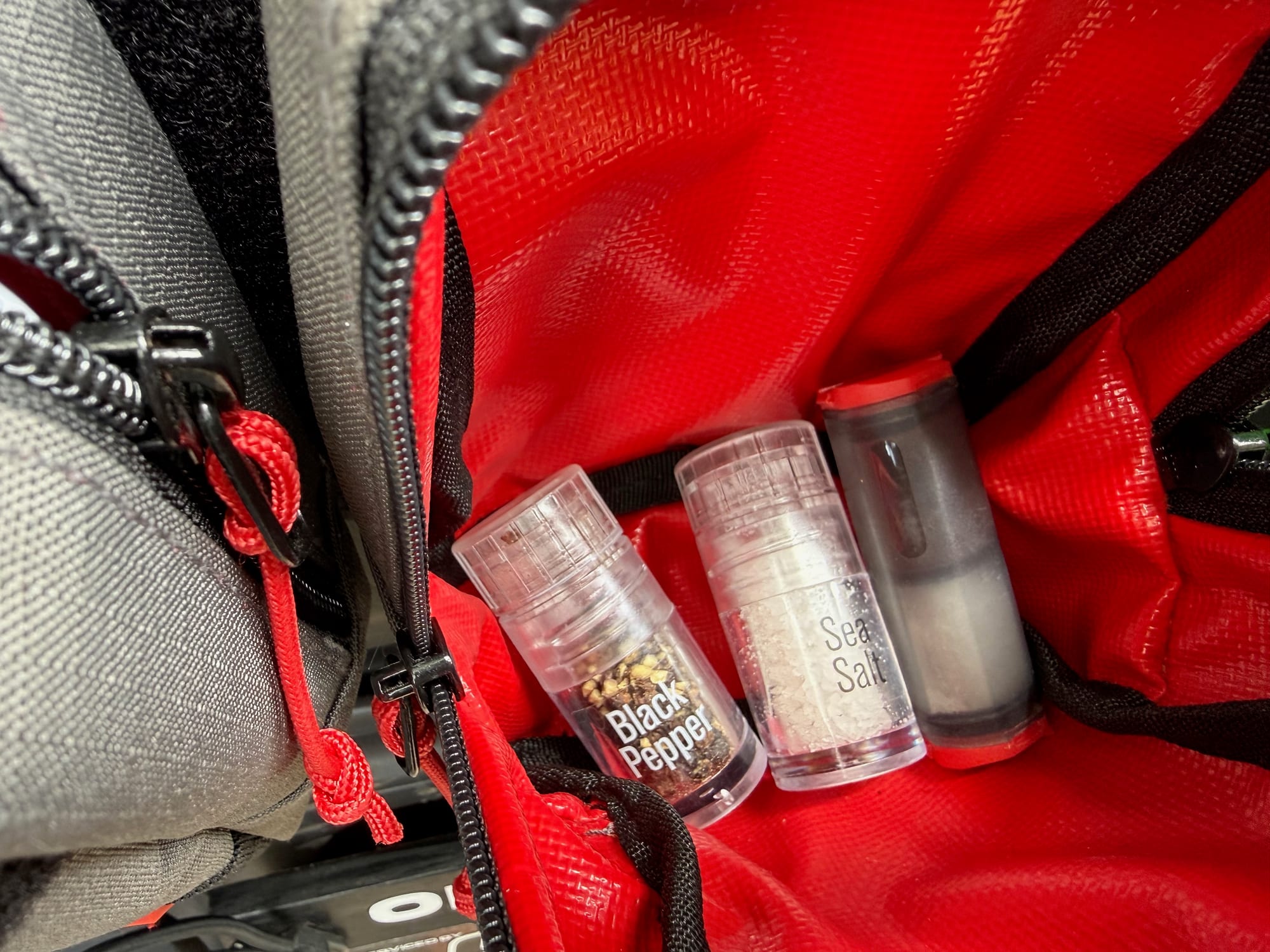 The AGS mini grinders in the red storage pouch on the back door of the Prado, next to the MSR Alpine shaker
