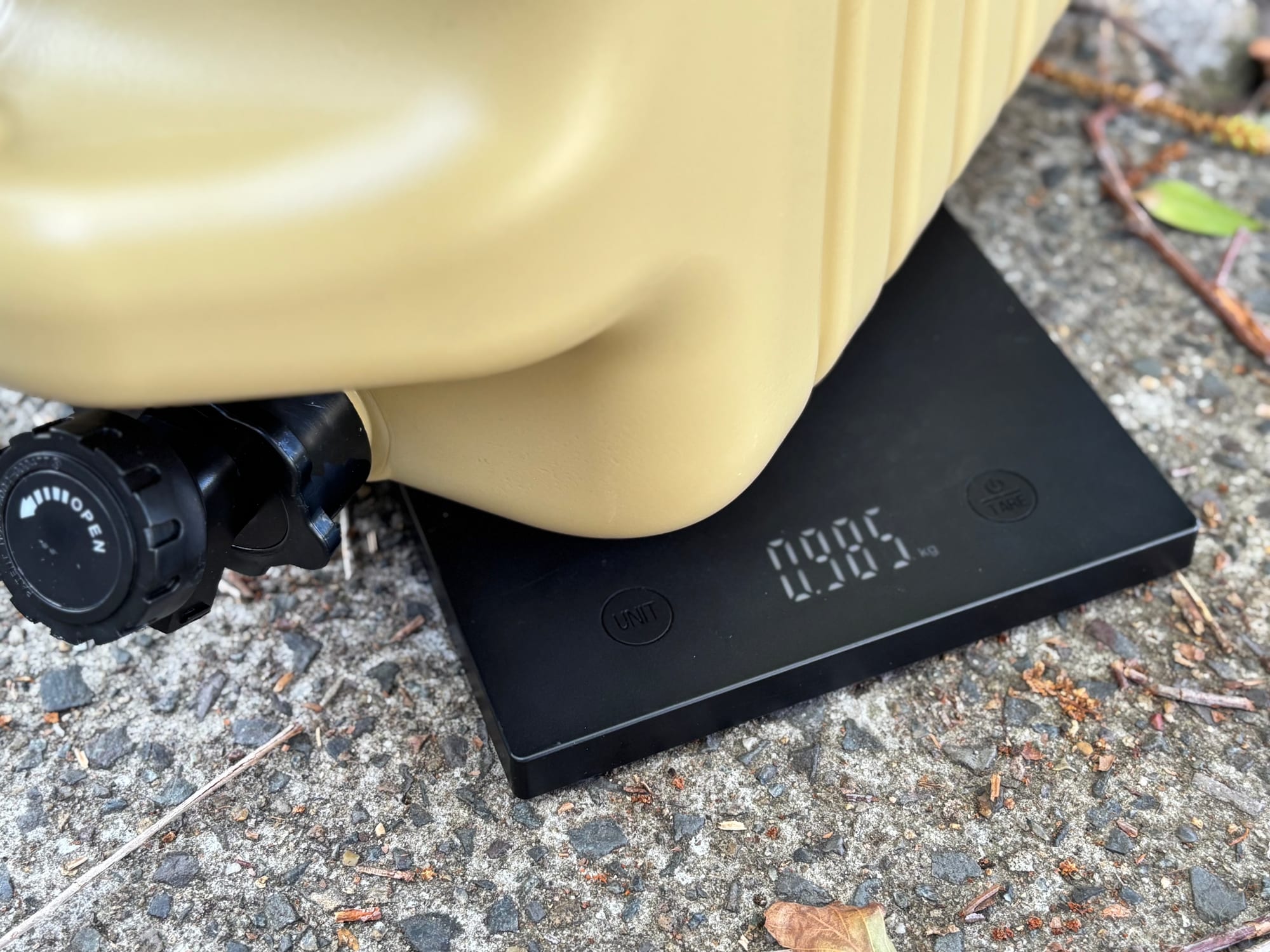 The Aimall 18.5L container on a kitchen scale showing 0.985 kg