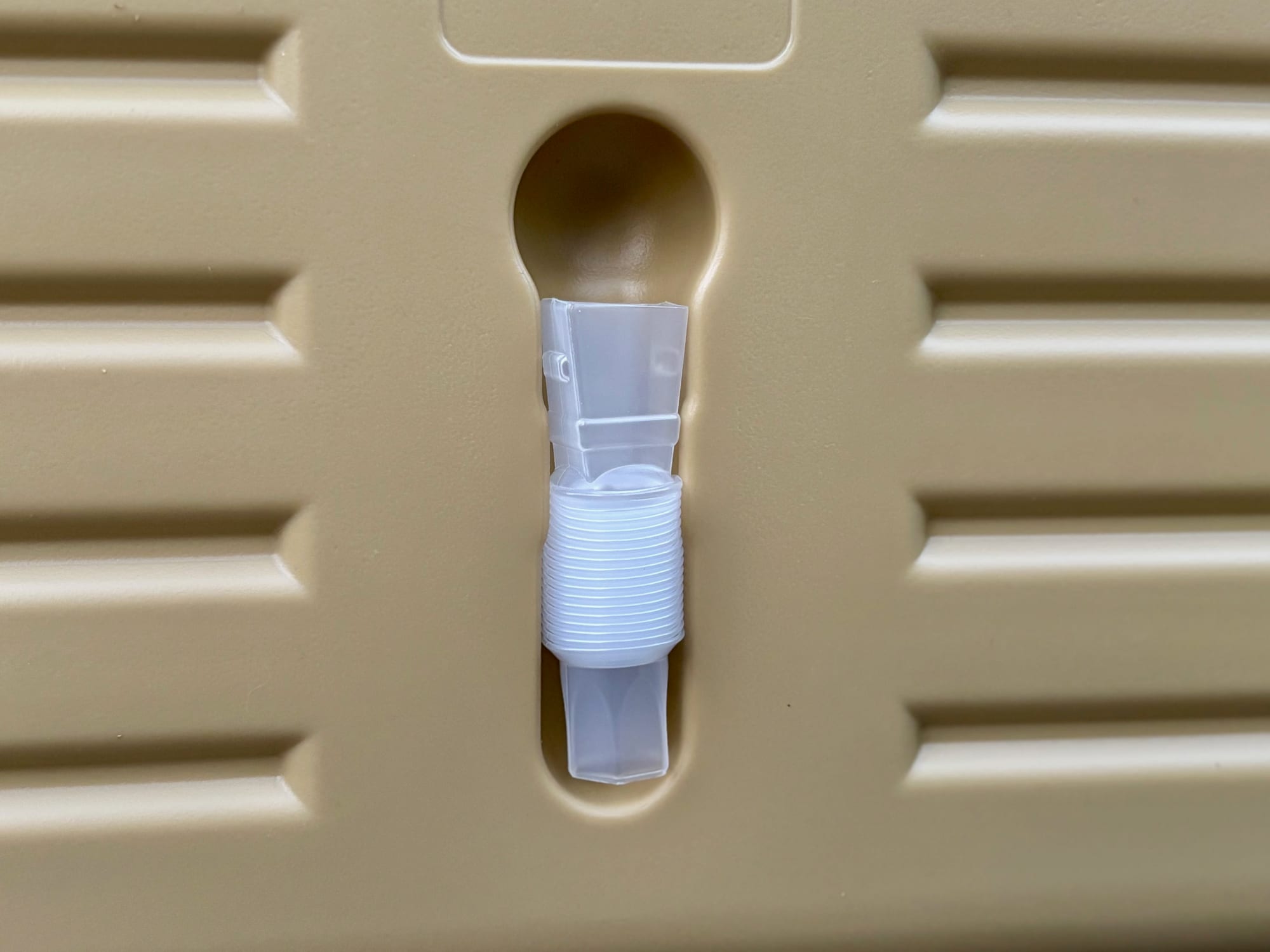 The clear concertina tap extension tube clipped into its keyhole slot in the side of the container