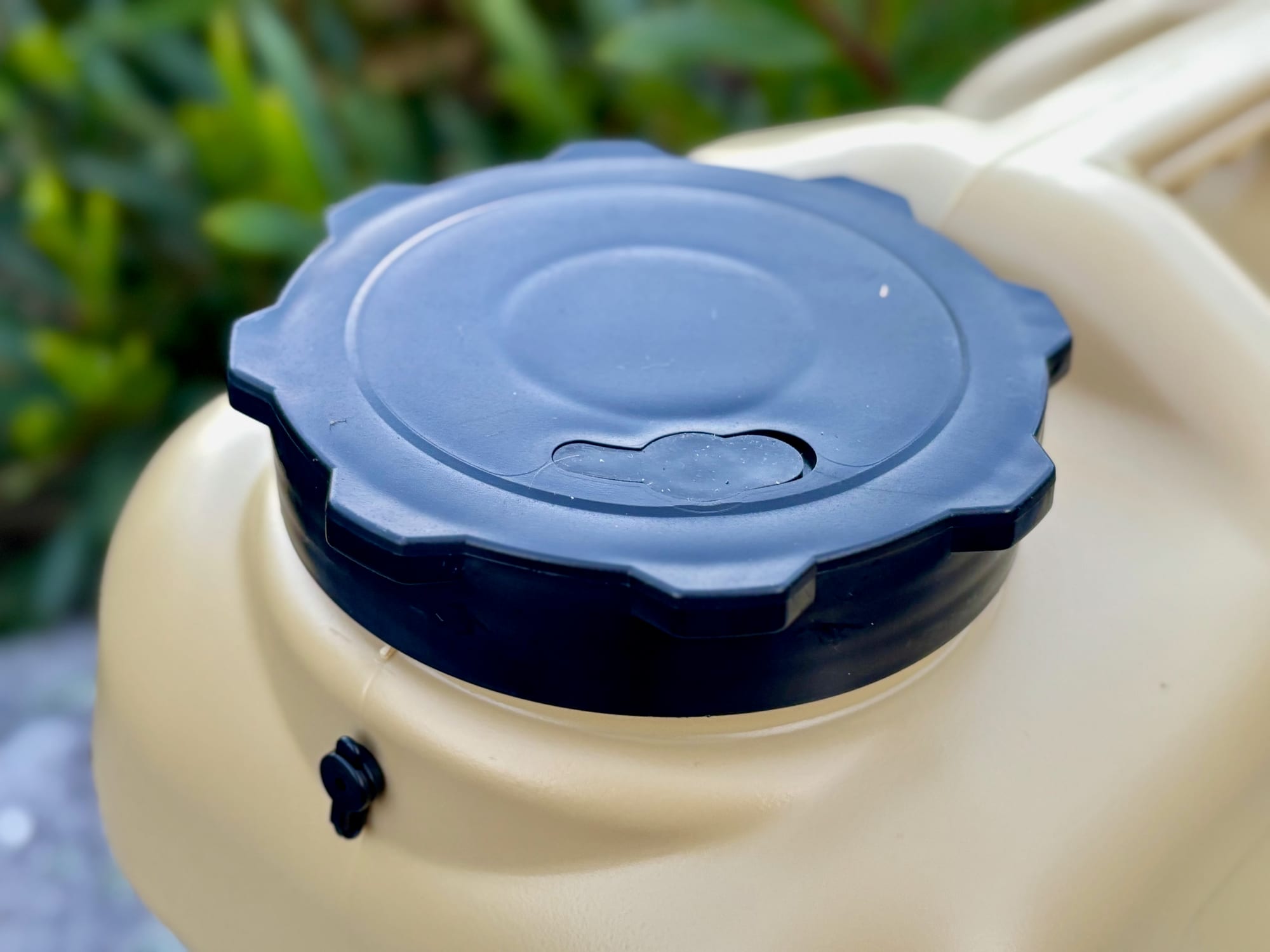 Close-up of the wide black screw lid with the small vent beside it