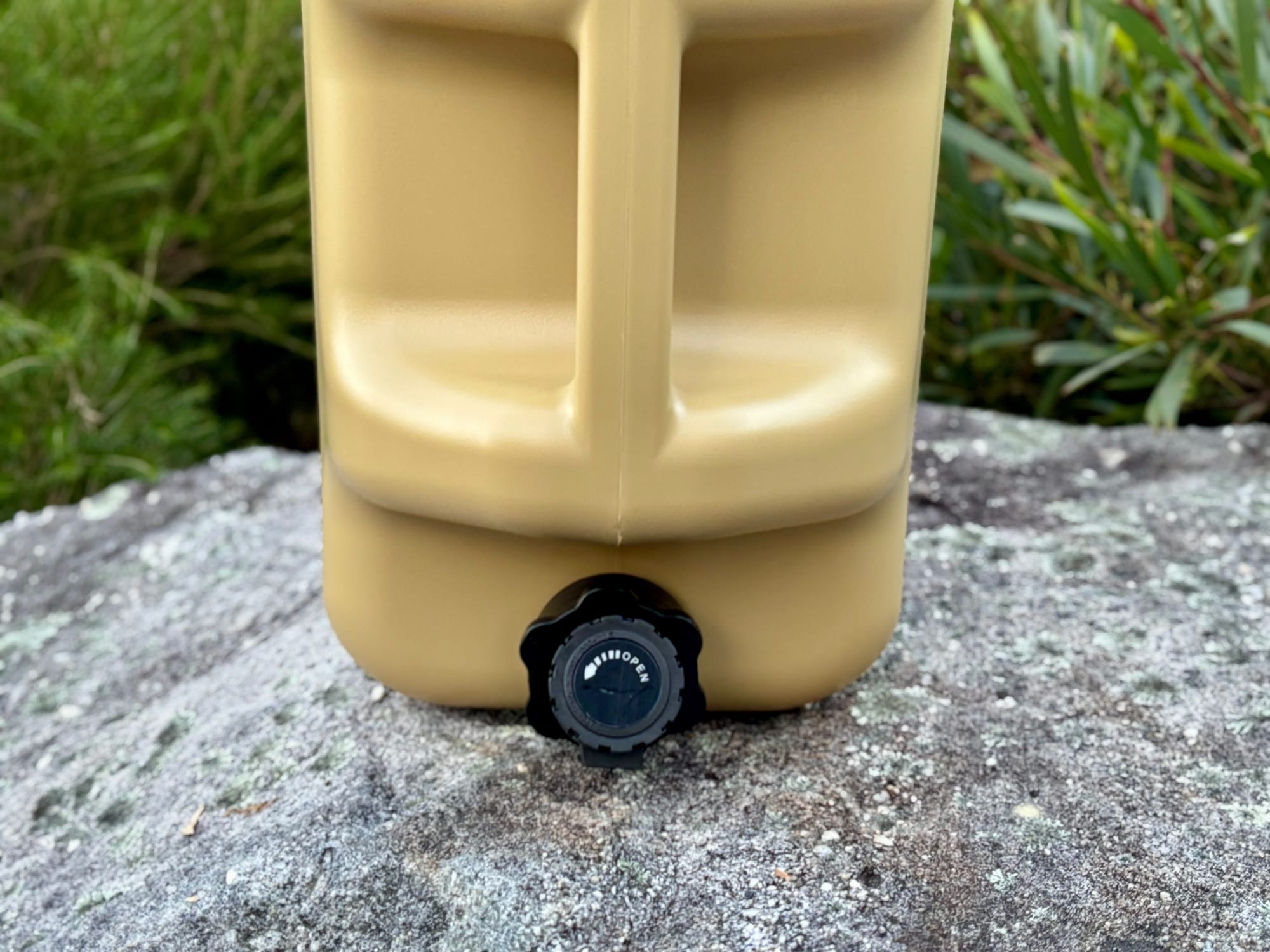 The tap at the bottom of the container, on a rock