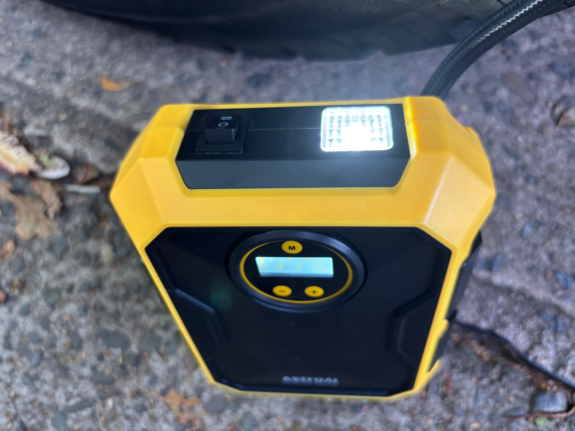 The LED light on top of the AstroAI tyre inflator switched on
