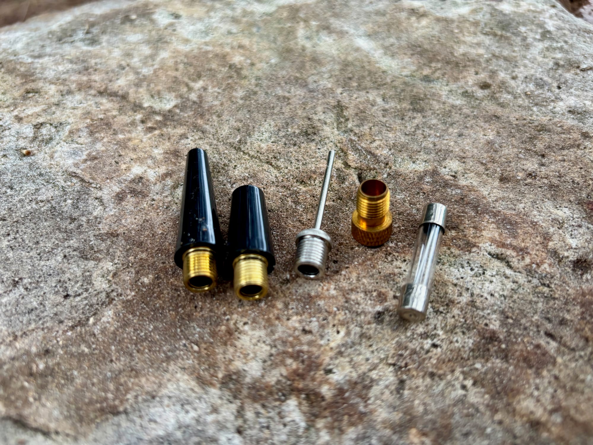 The two cone nozzles, ball needle, brass valve adapter and spare fuse that come with the AstroAI inflator