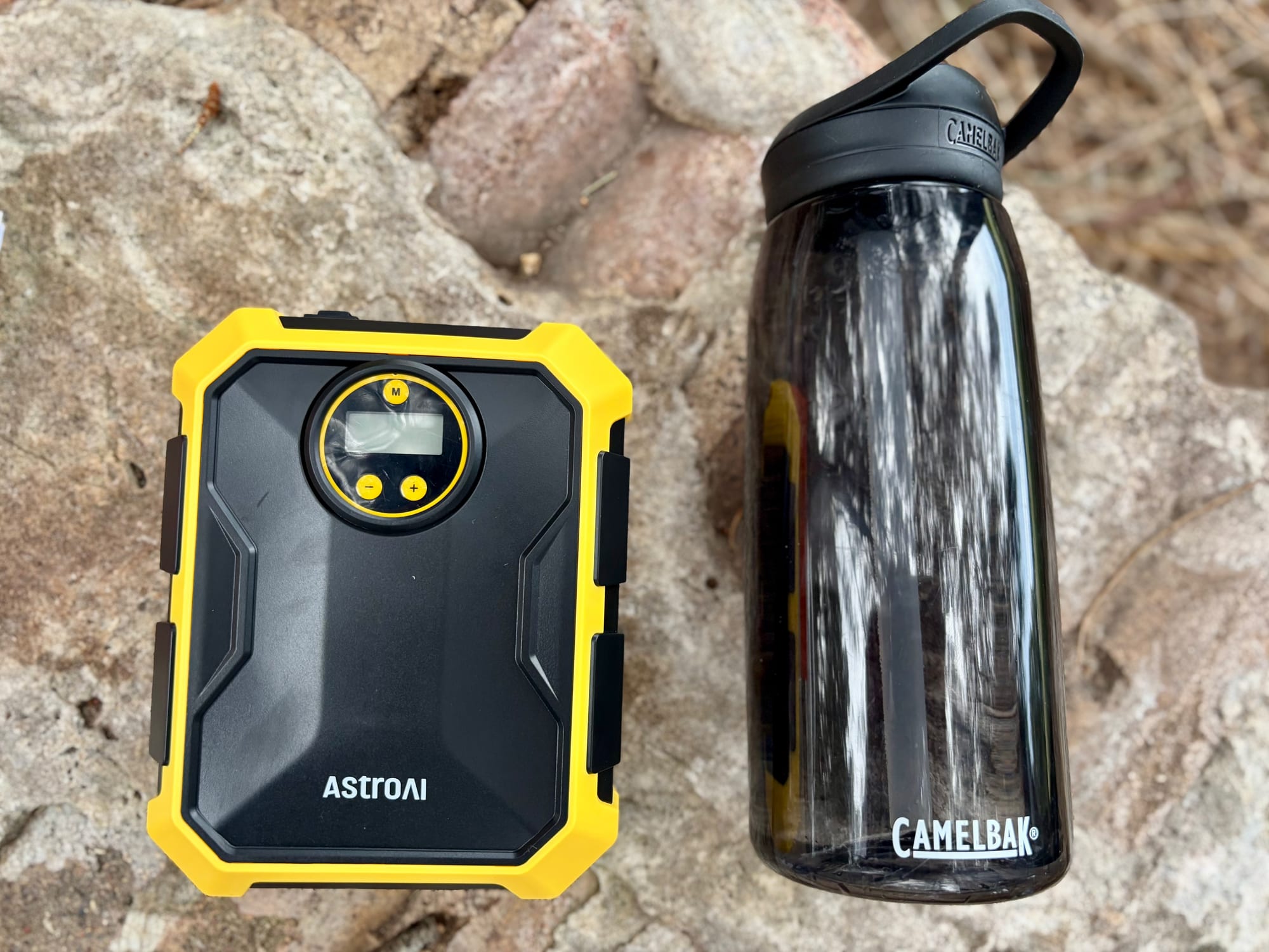 The AstroAI 12V tyre inflator next to a water bottle to show its size