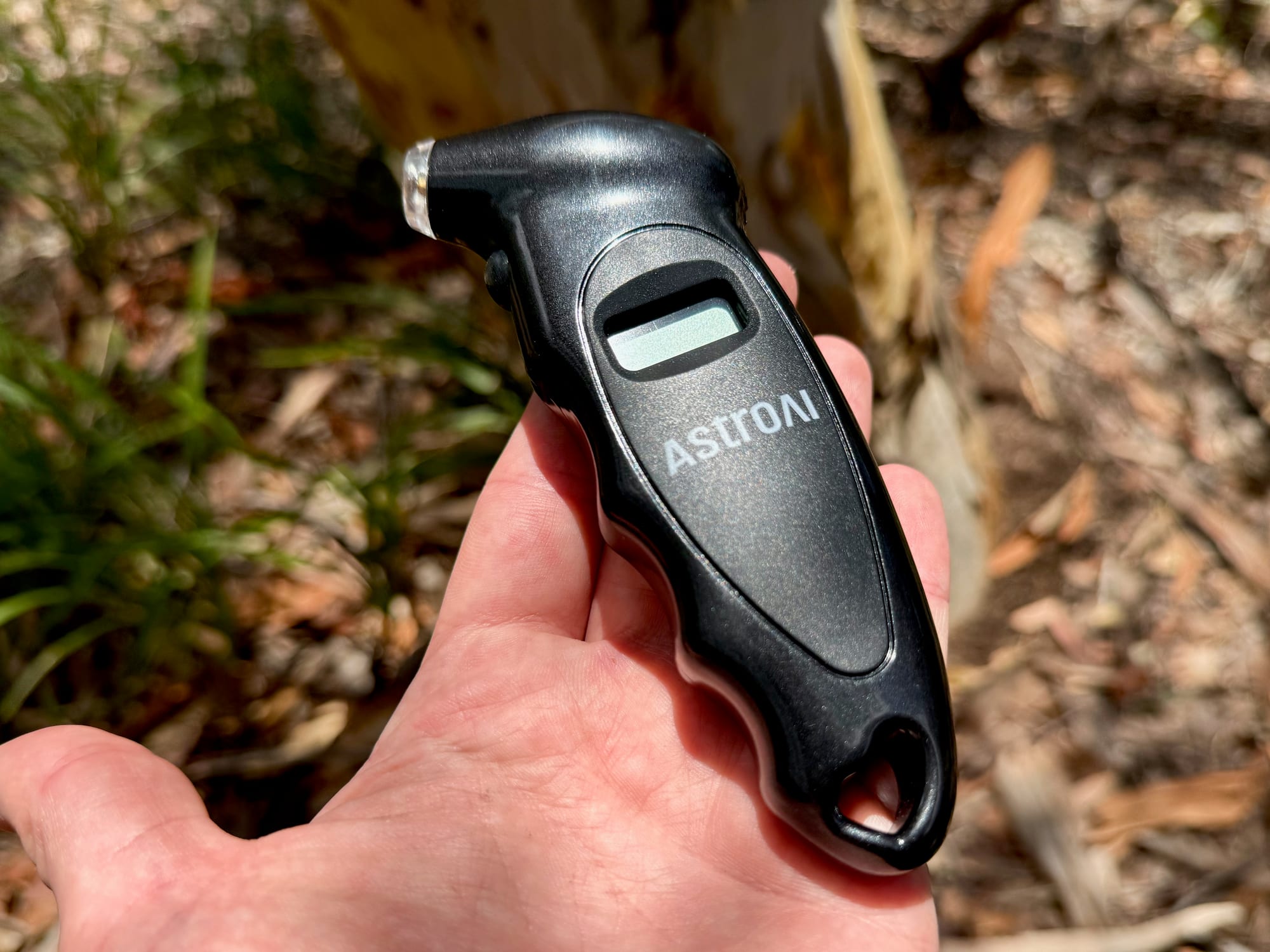 The AstroAI tyre pressure gauge in the palm of a hand