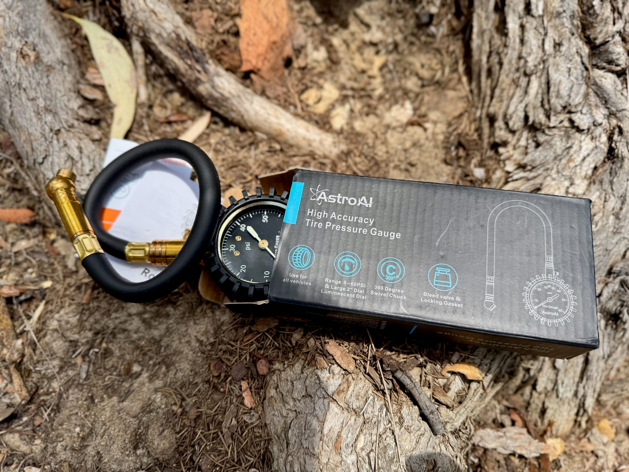 The AstroAI High Accuracy Tire Pressure Gauge box with the gauge beside it