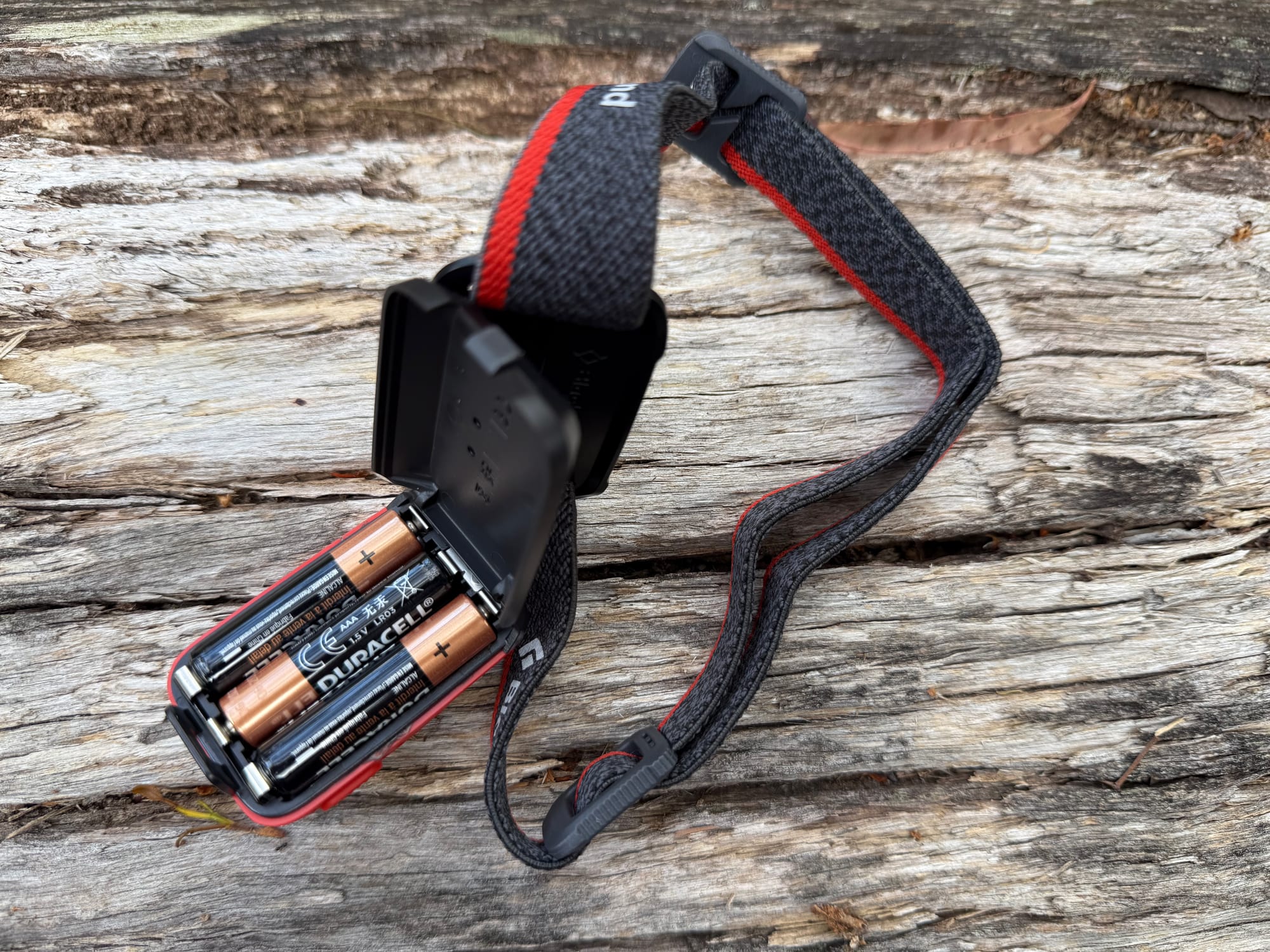 The battery compartment of the Spot 400 open, with three AAA batteries inside