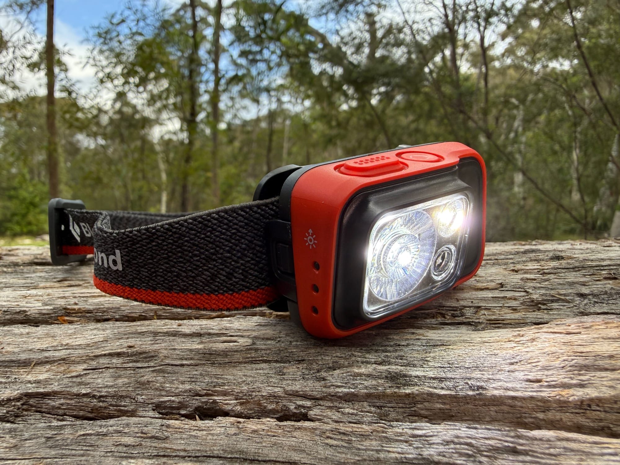 The Spot 400 with its white light on, on a weathered log
