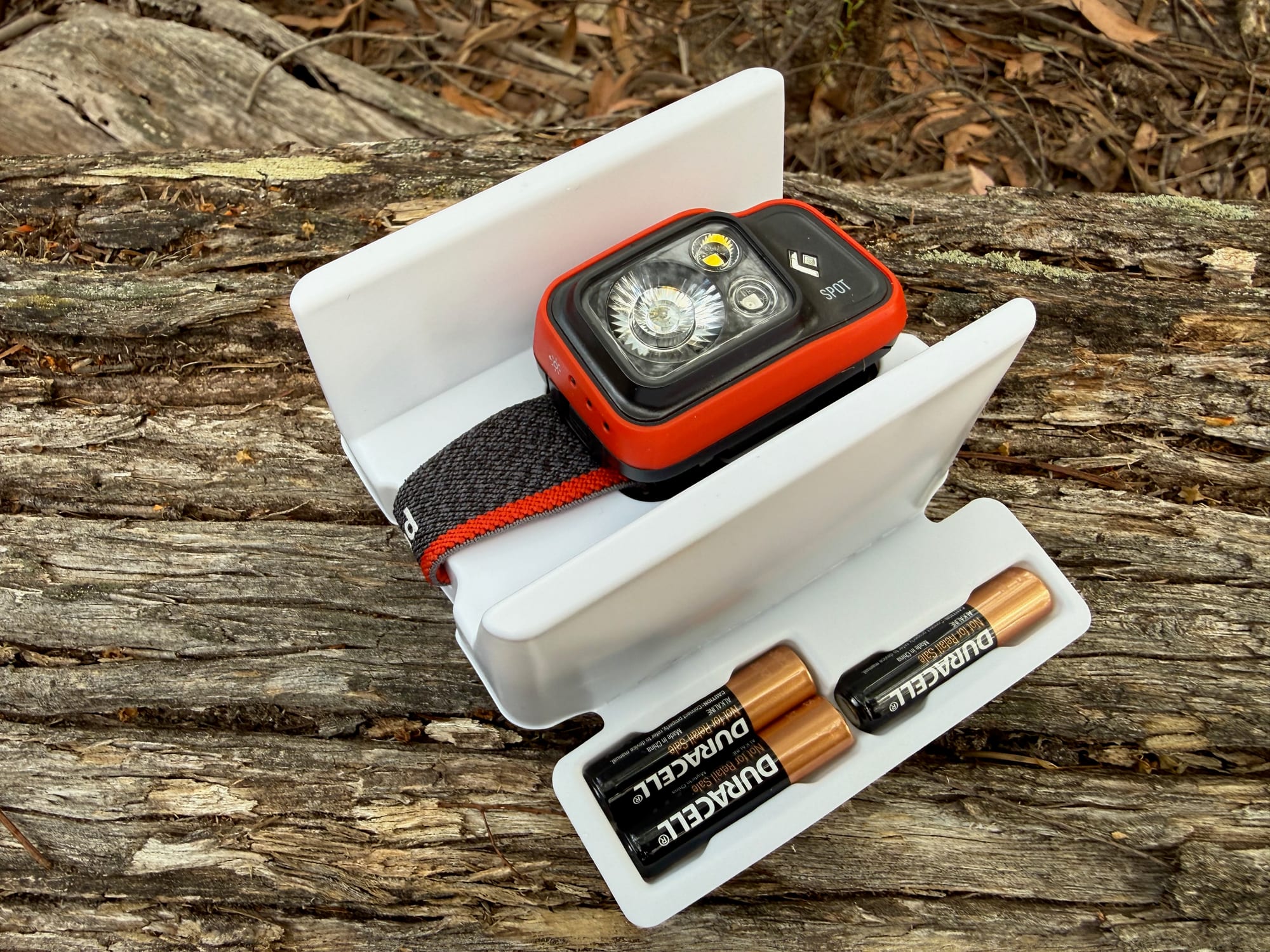The Spot 400 in its box tray with the three AAA Duracell batteries that come with it
