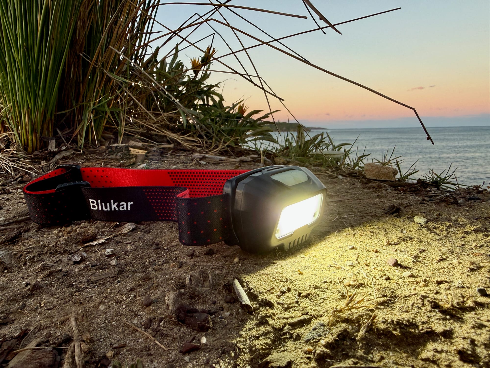 The Blukar K9112 headlamp switched on at dusk, by the sea