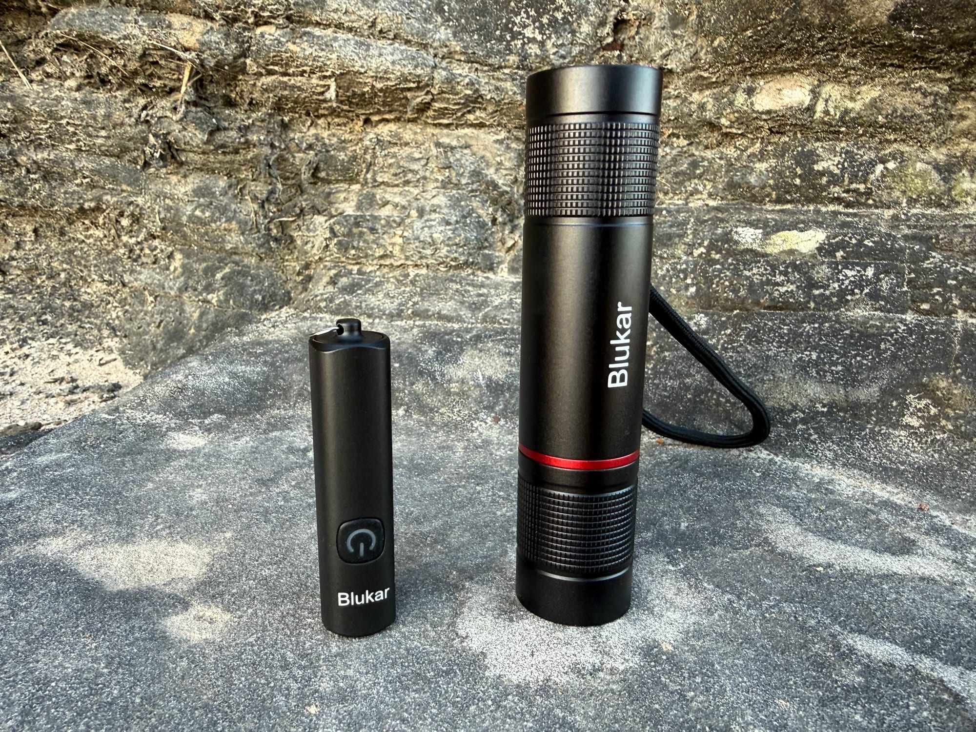 The Blukar Mini Torch standing next to the bigger Blukar Torch on a rock