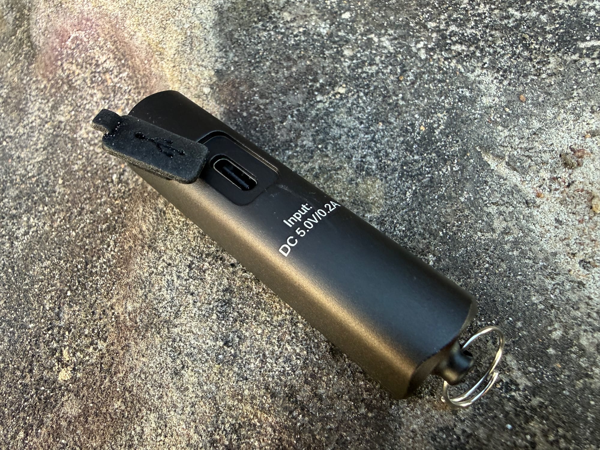 The rubber cover lifted off the USB-C port of the Blukar Mini Torch, marked Input DC 5.0V/0.2A