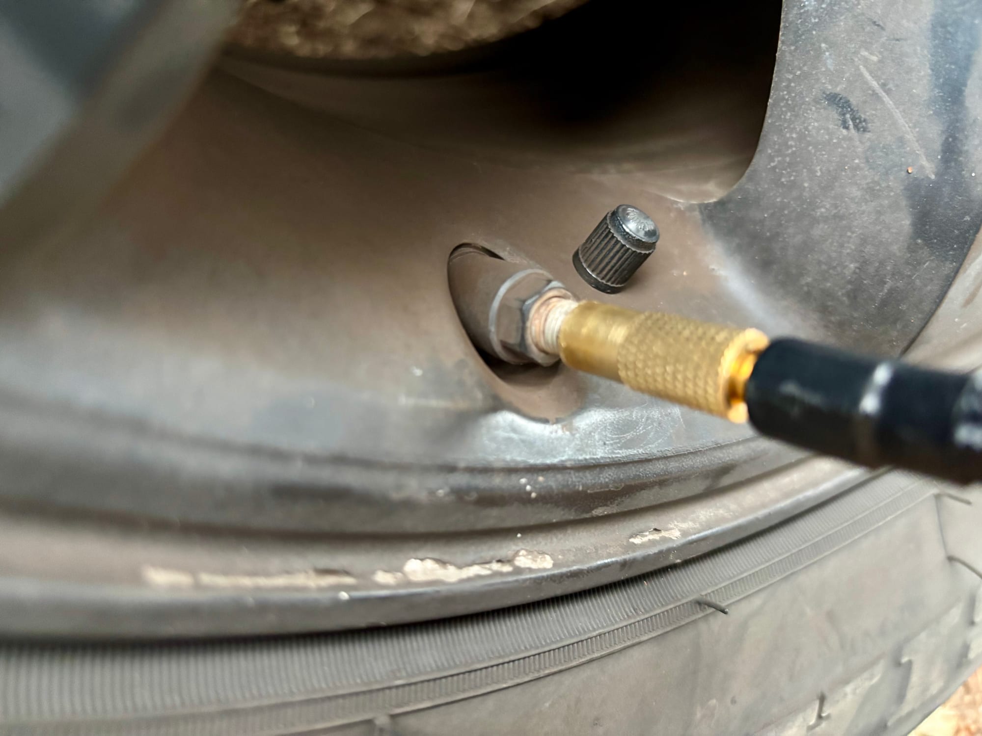 The brass connector of the Bosch EasyPump screwed onto a tyre valve