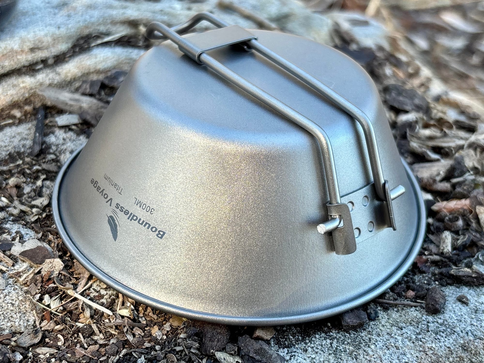 The 300 ml titanium bowl upside down with its handle folded flat across the base, showing the 300ML marking
