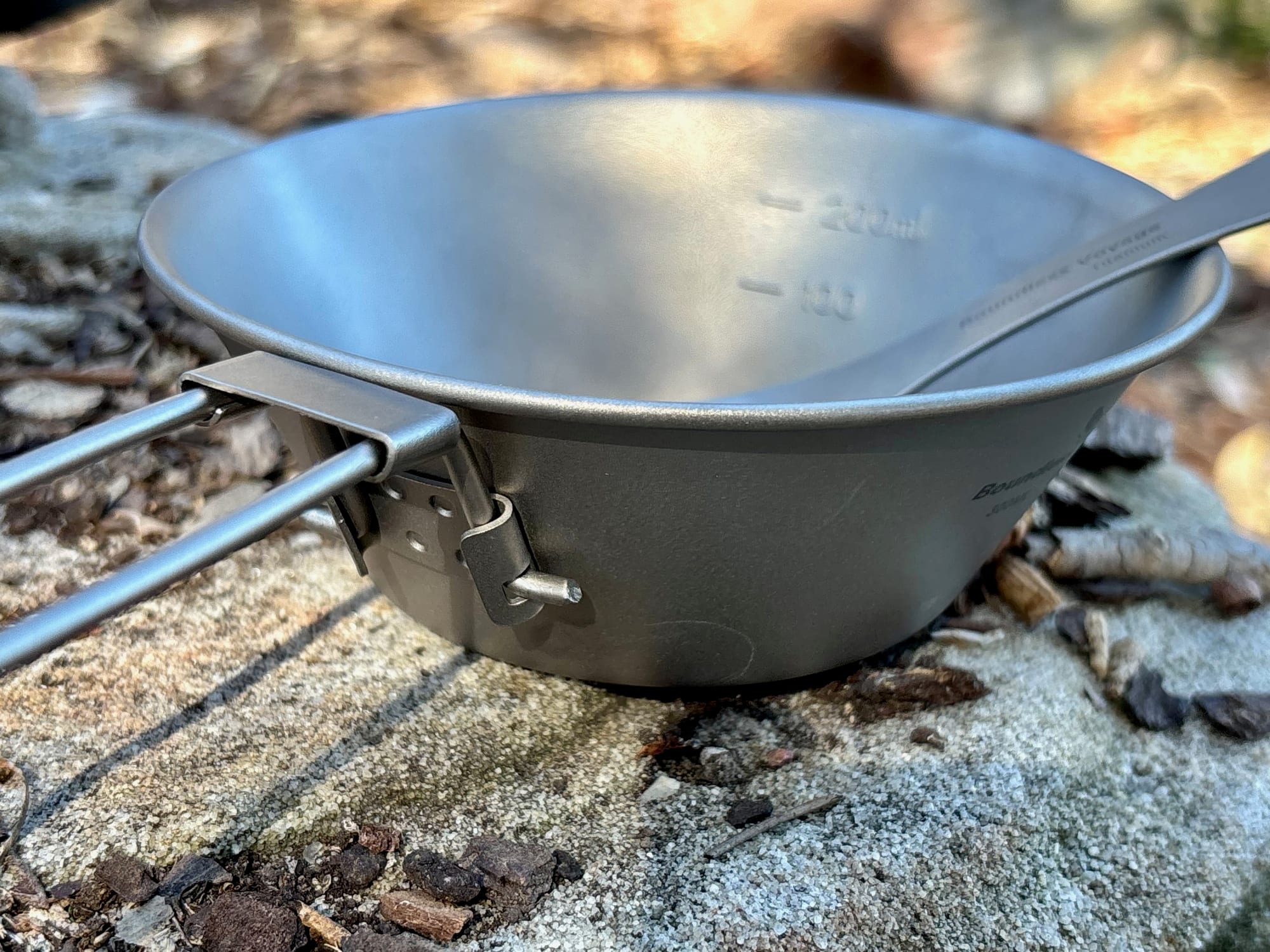 The 300 ml bowl with its handle folded out, side on, with a spork resting inside