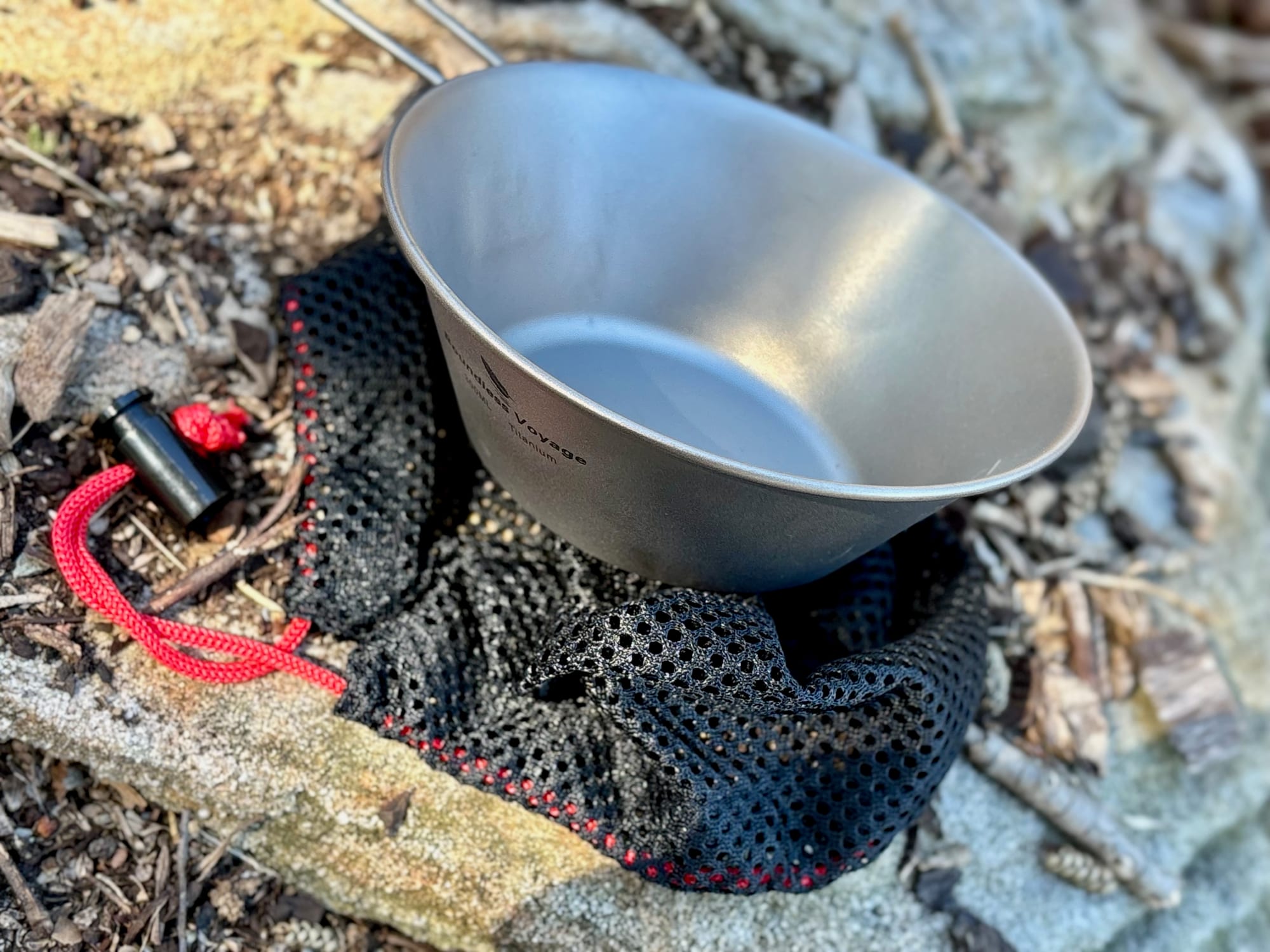 The 300 ml bowl sitting on its black mesh bag with a red drawcord