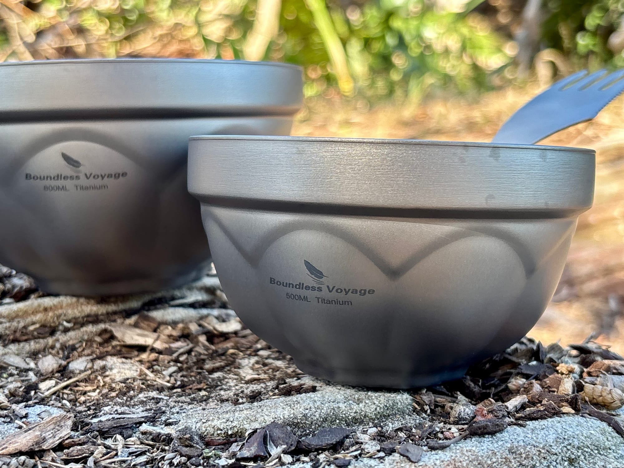 The 500 ml titanium bowl from the side, with the Boundless Voyage 500ML Titanium marking and the plum-blossom pattern