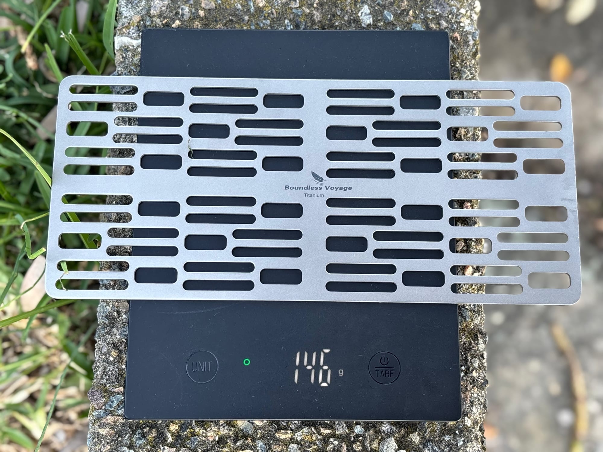 The Ti2023C titanium grill plate on a digital scale showing 146 grams