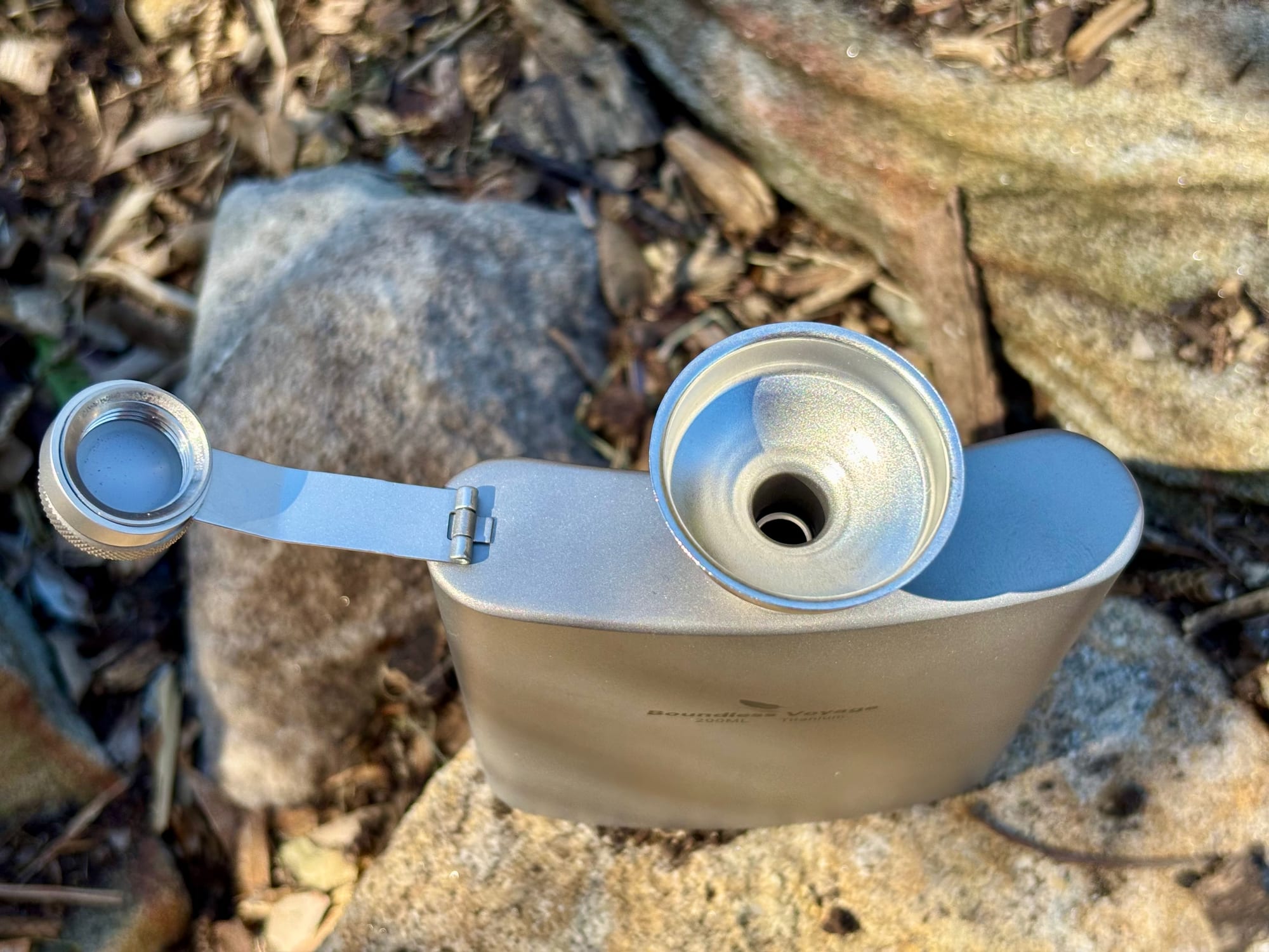 The funnel sitting in the neck of the flask, with the cap swung aside
