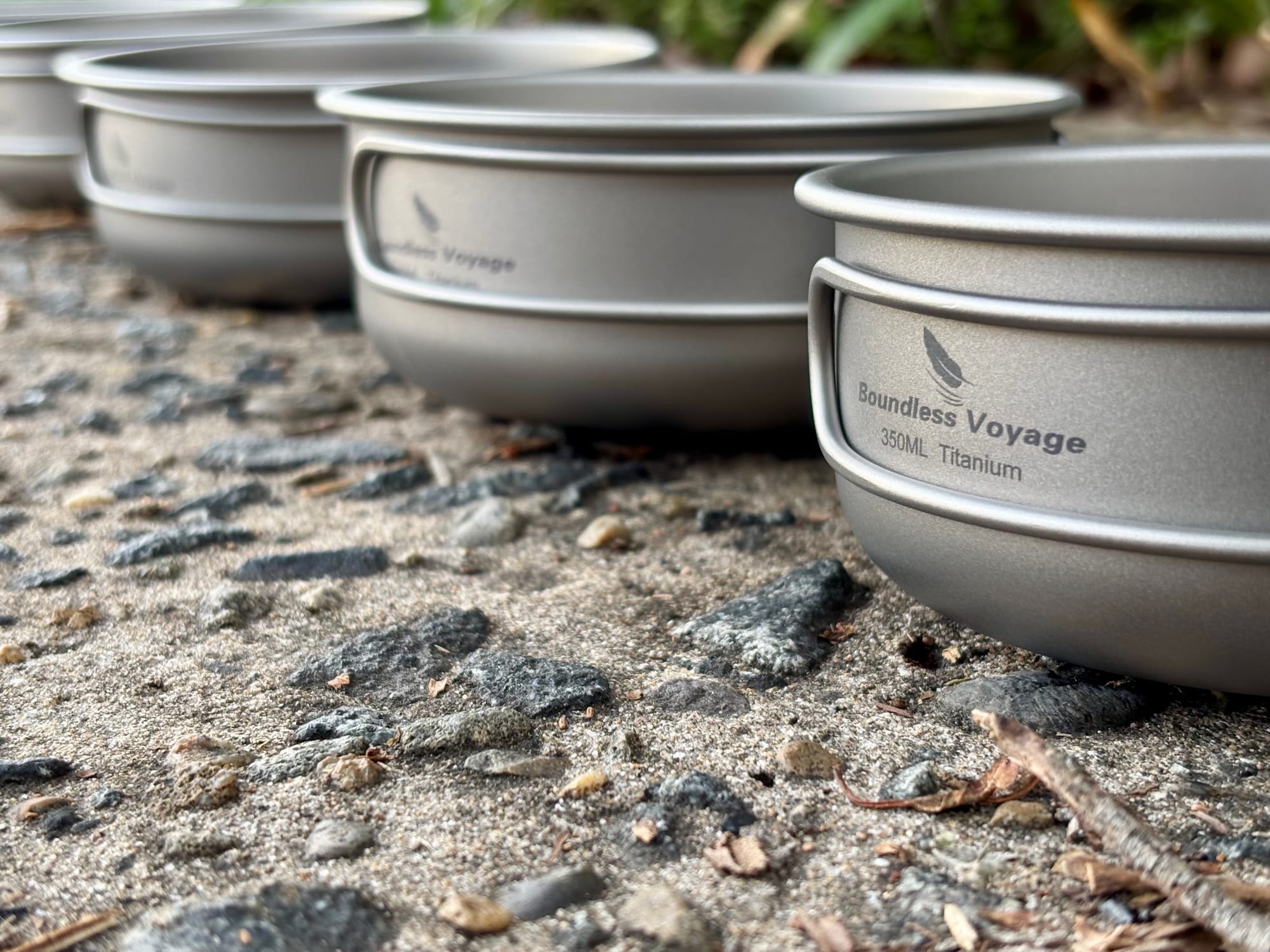 Three of the Boundless Voyage titanium pans side by side, the nearest showing its logo and size marking