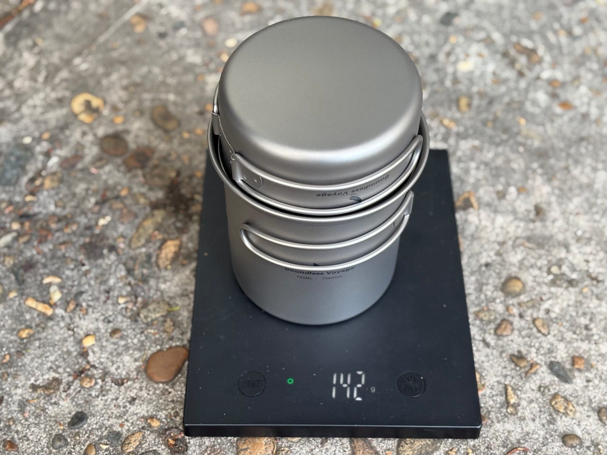 The 750 ml pot with the 300 ml pan on top as a lid, on a digital scale showing 142 grams