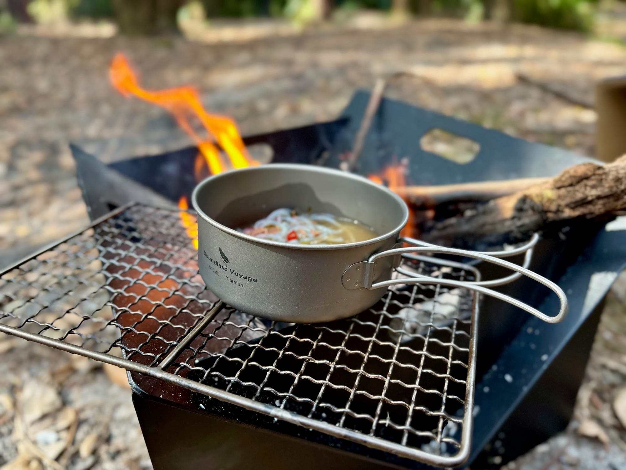 Noodle soup cooking in the titanium pan over the fire