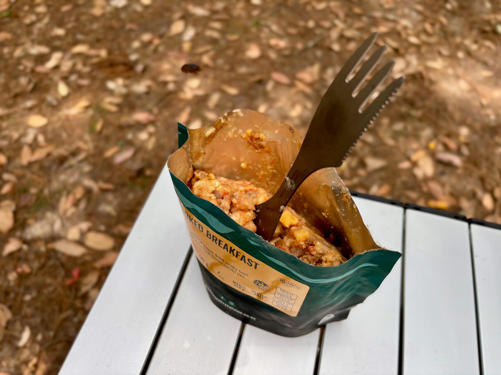 The fork end of the titanium spork in a meal pouch, with the serrated edge visible