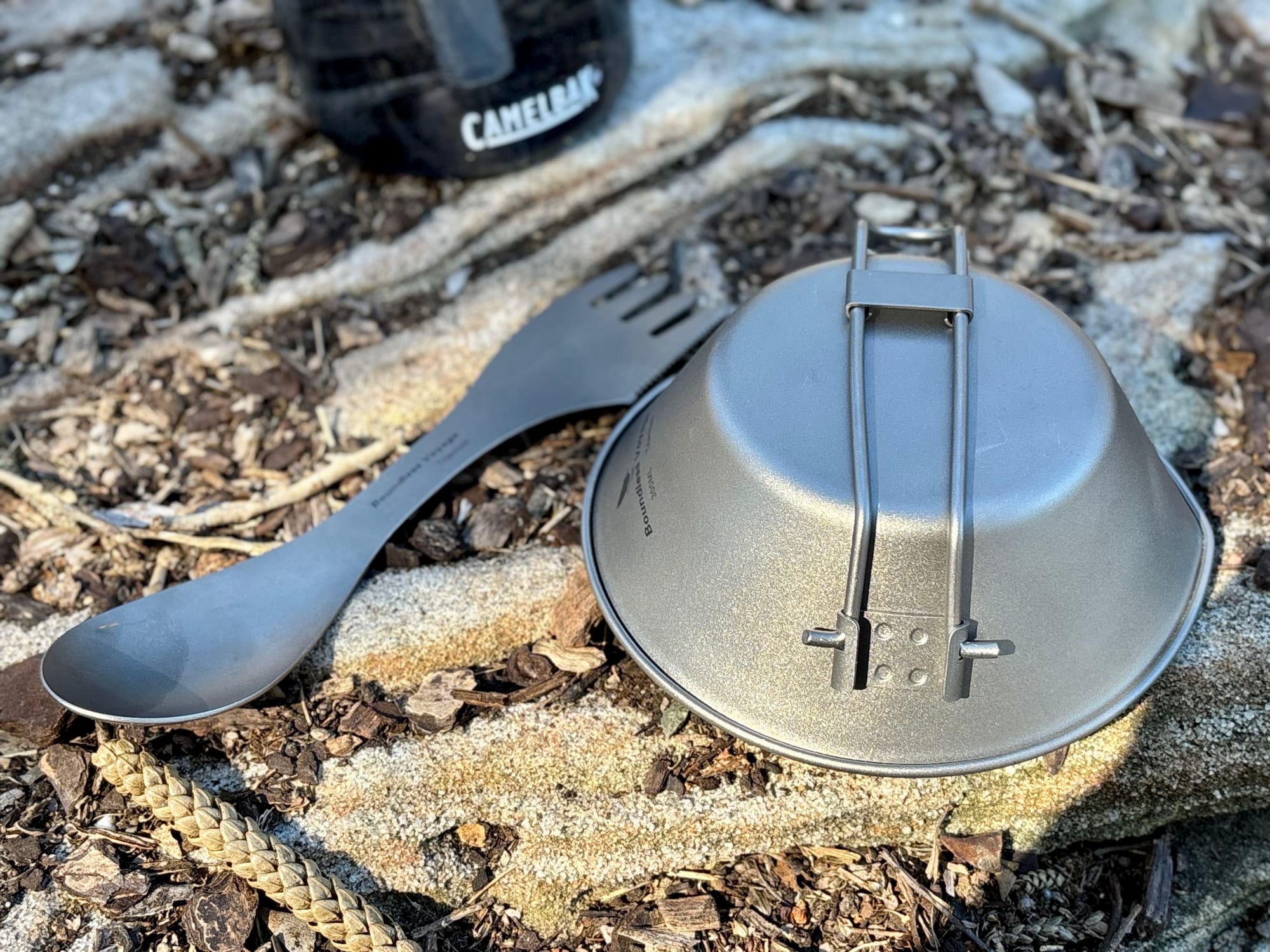 The titanium spork next to the upturned 300 ml titanium bowl with its folding handle