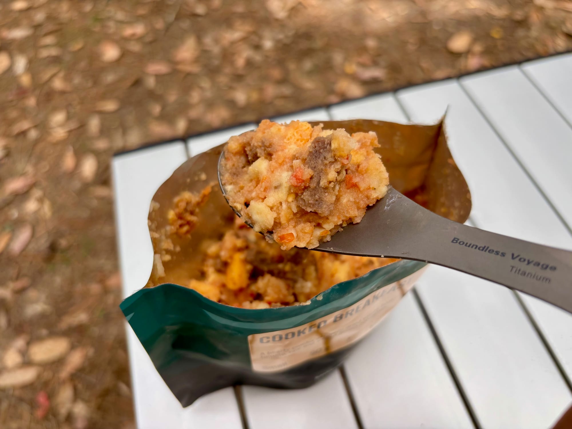 Scooping a freeze-dried cooked breakfast out of the pouch with the spoon end of the titanium spork