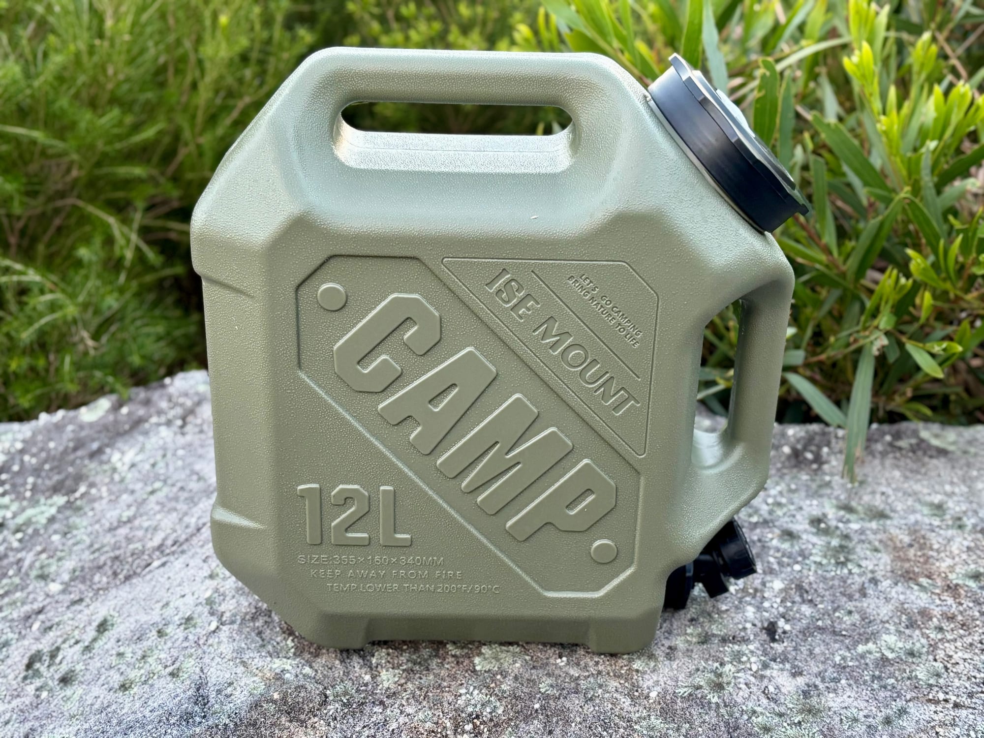 The green 12 litre container from the front, with CAMP 12L moulded into the side, on a rock