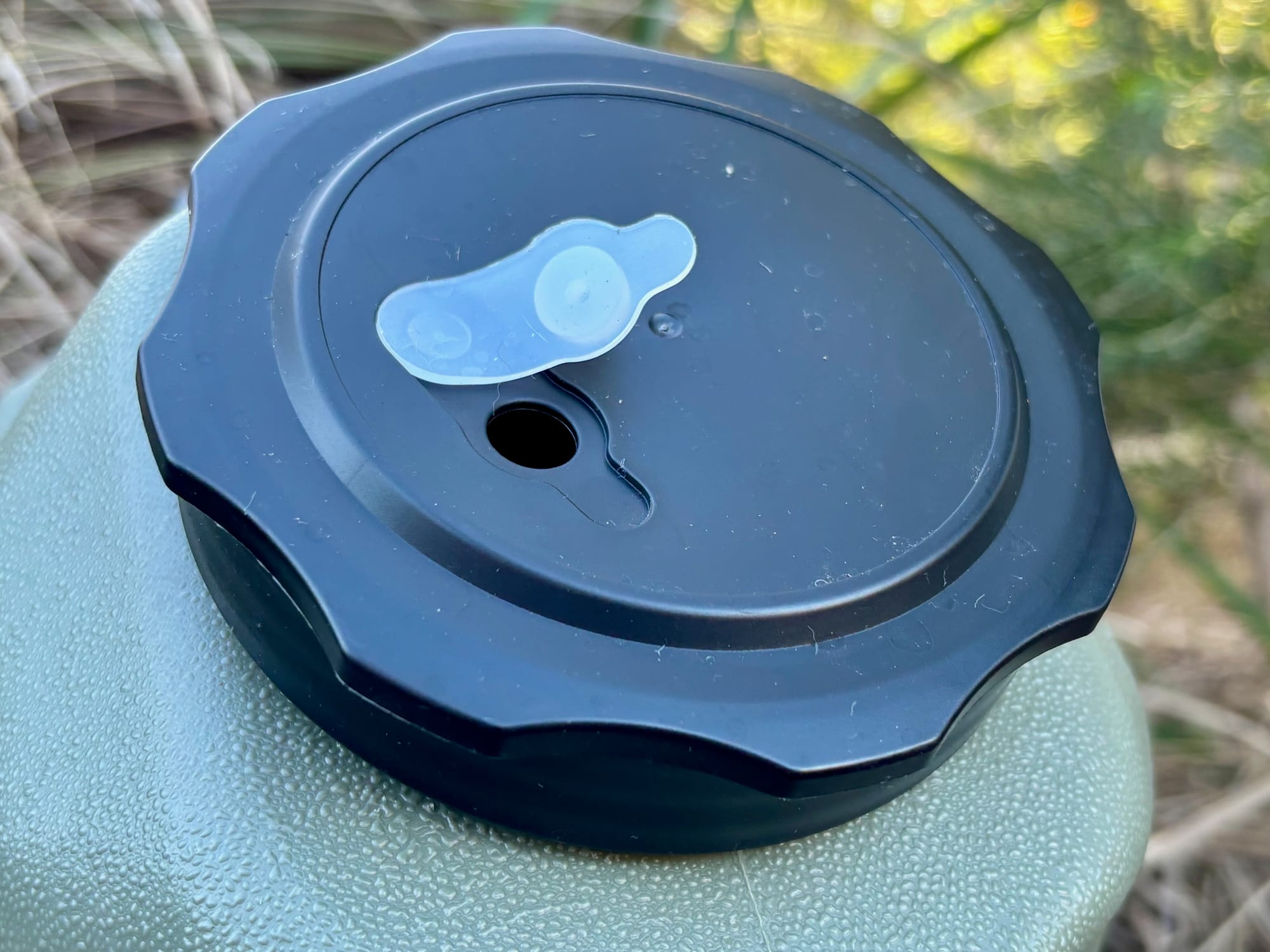Close-up of the black screw lid with its white vent plug on top