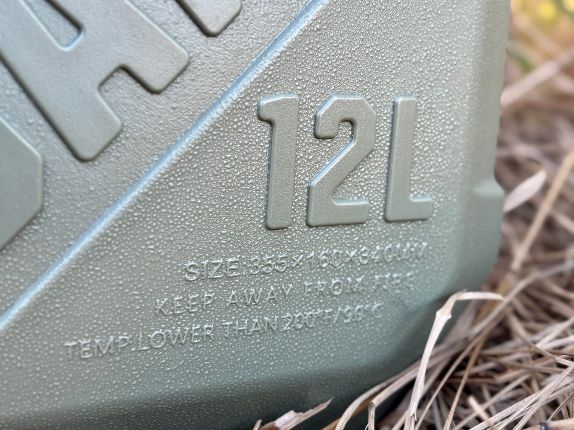 Close-up of the 12L label moulded into the side, with the size and temperature warning