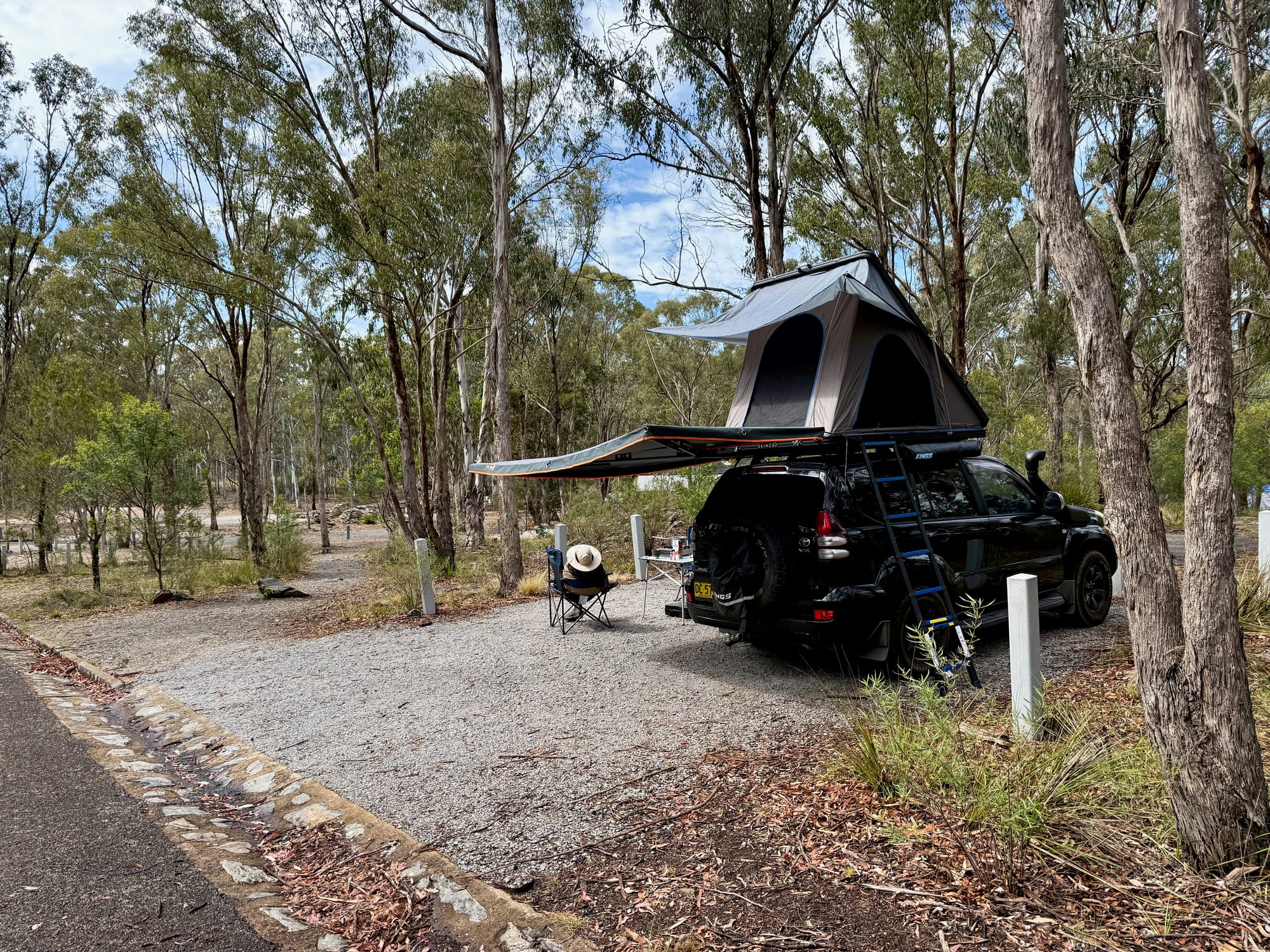 Our 4WD with the rooftop tent open and the awning out on a gravel site at Bungonia Campground