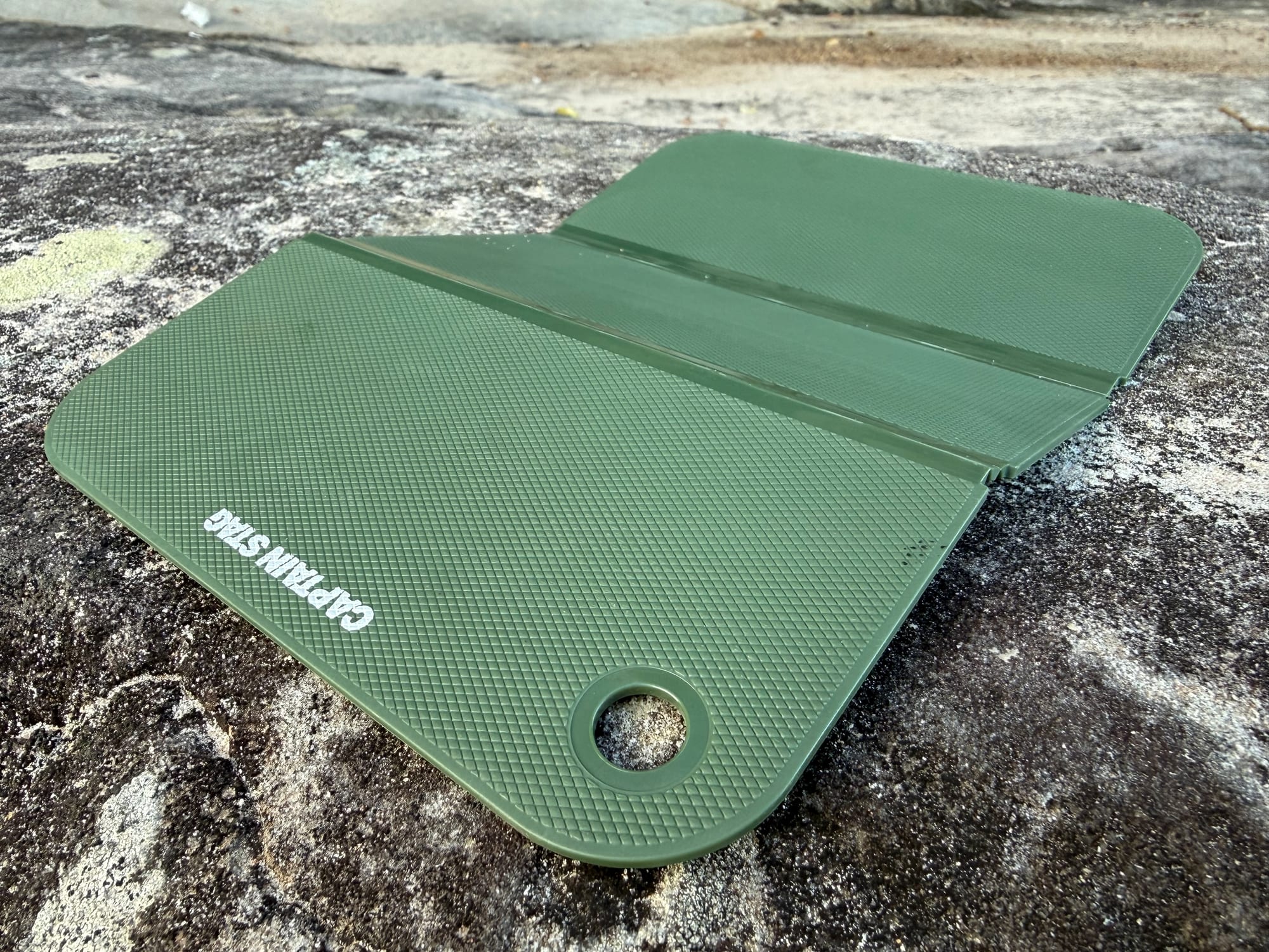 The Captain Stag cutting board opened out on a sandstone rock, its folds slightly raised