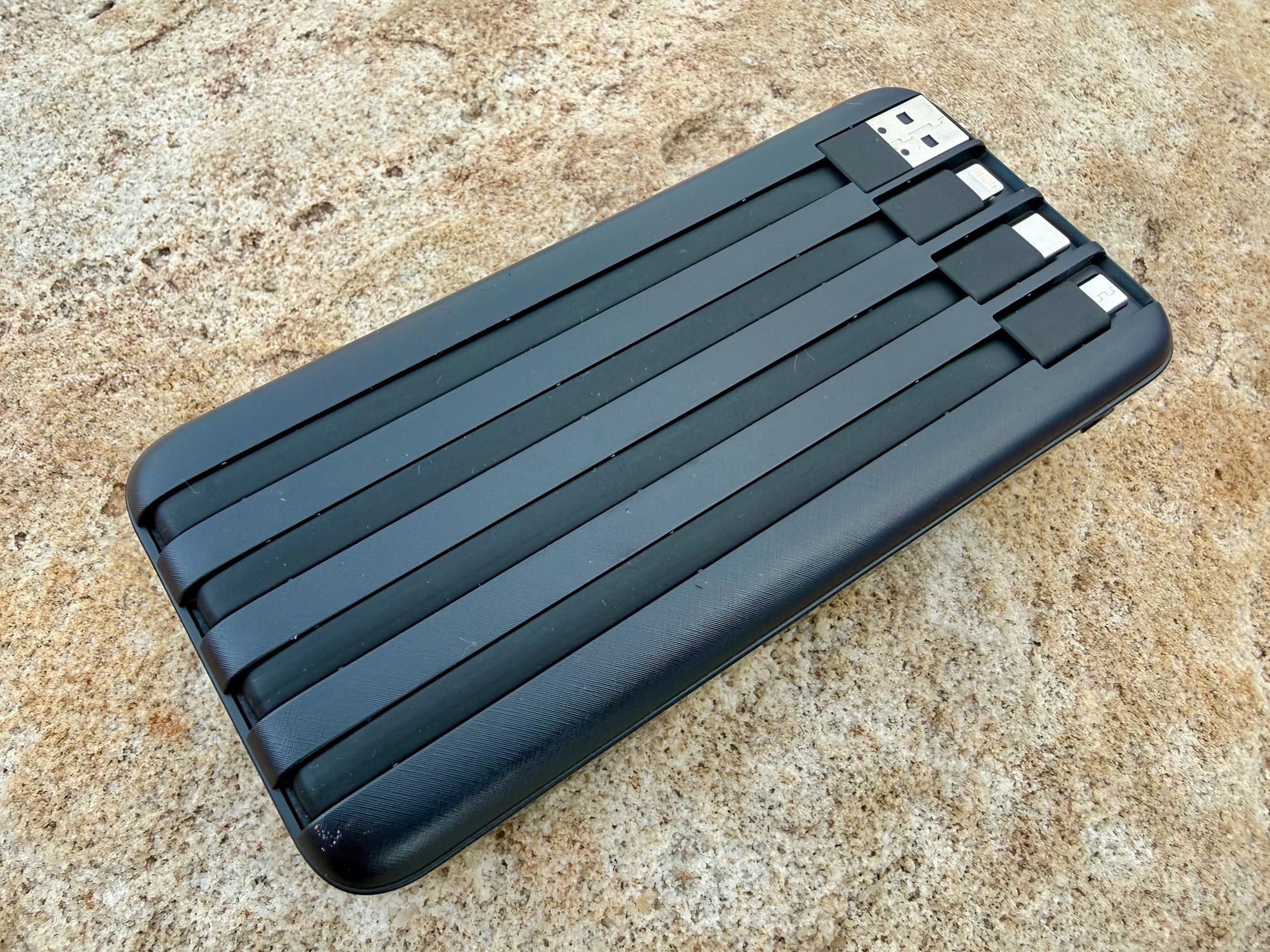 The back of the Charmast power bank with the four cables tucked into their grooves