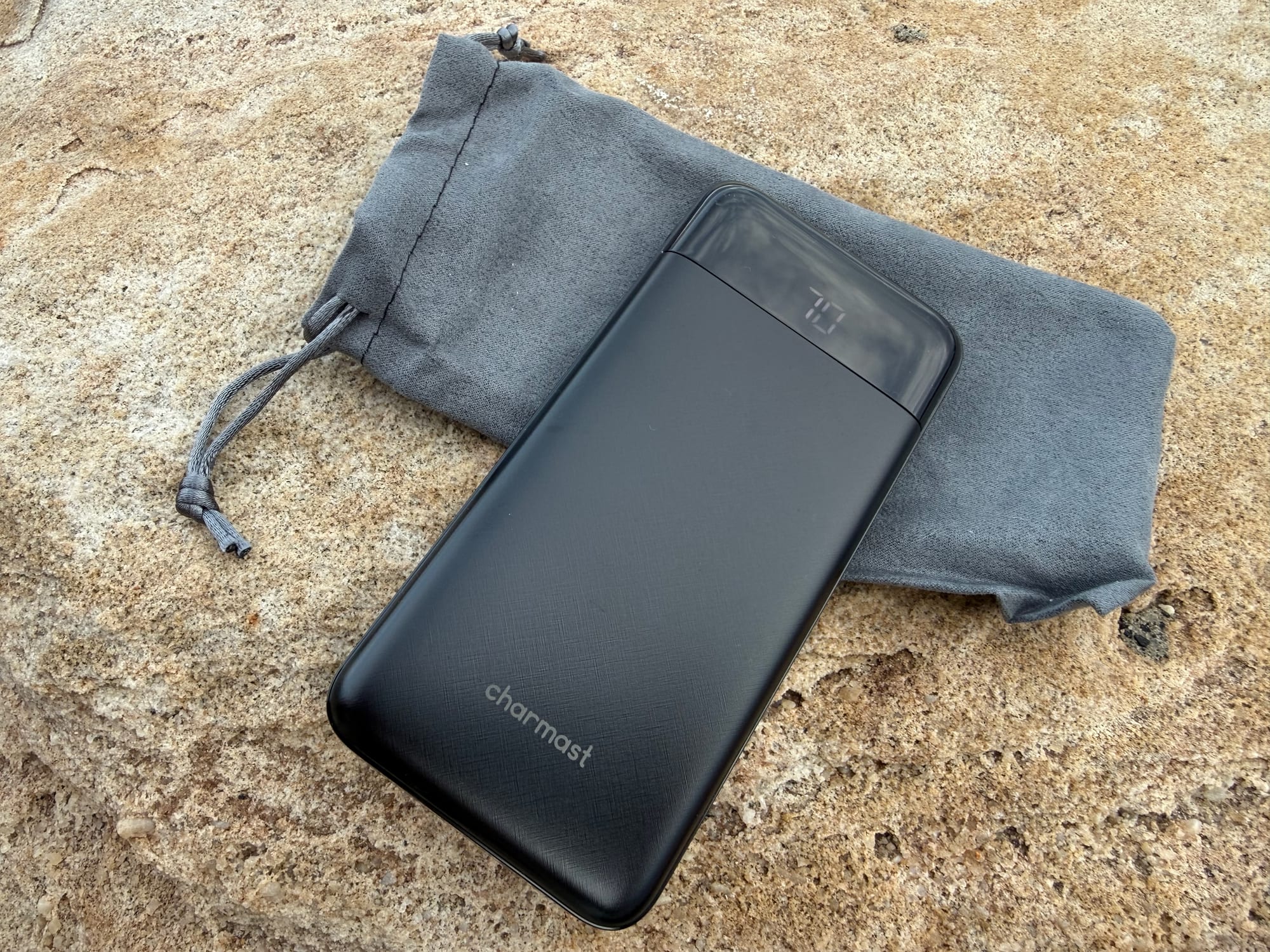 The Charmast 10,000mAh power bank on its grey drawstring pouch
