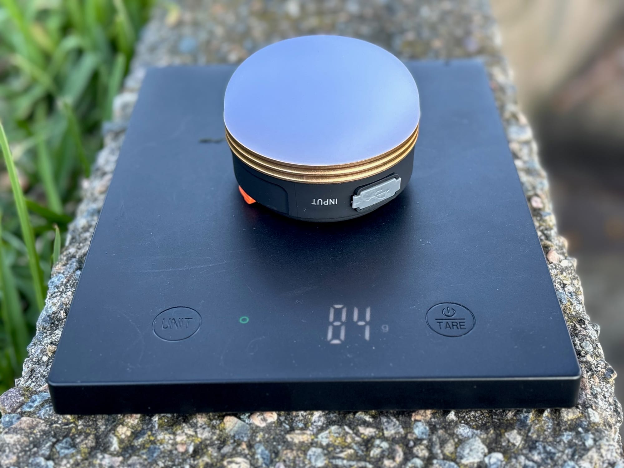 The Clearhill camping lantern on a scale showing 84 g