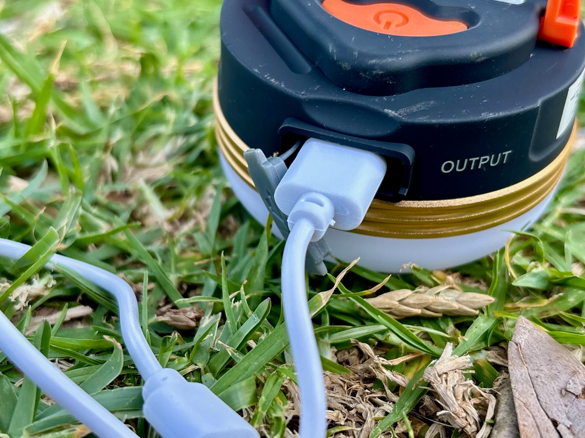 A USB cable plugged into the USB-A output port on the side of the Clearhill lantern