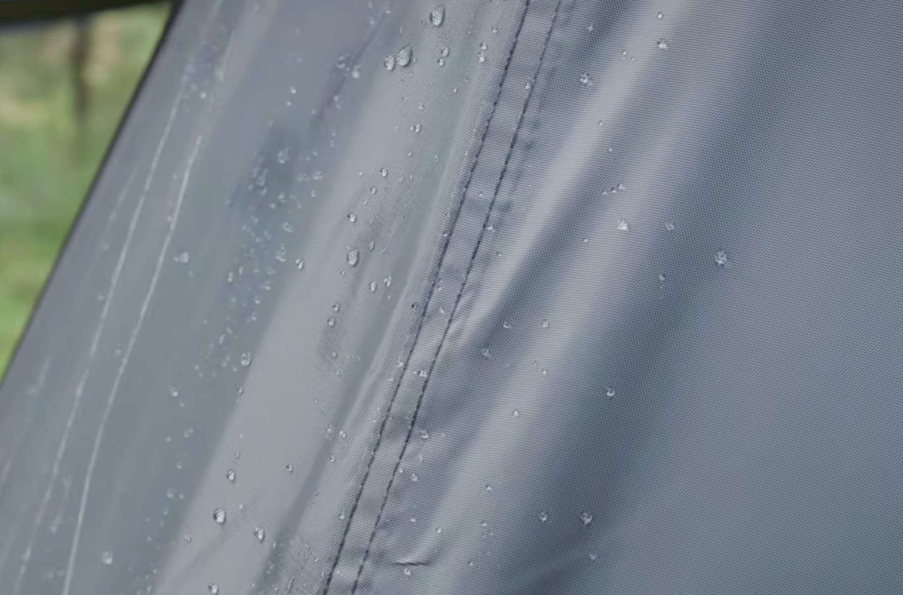 Water drops beading on the grey fly of the Coleman tent, beside a sealed seam