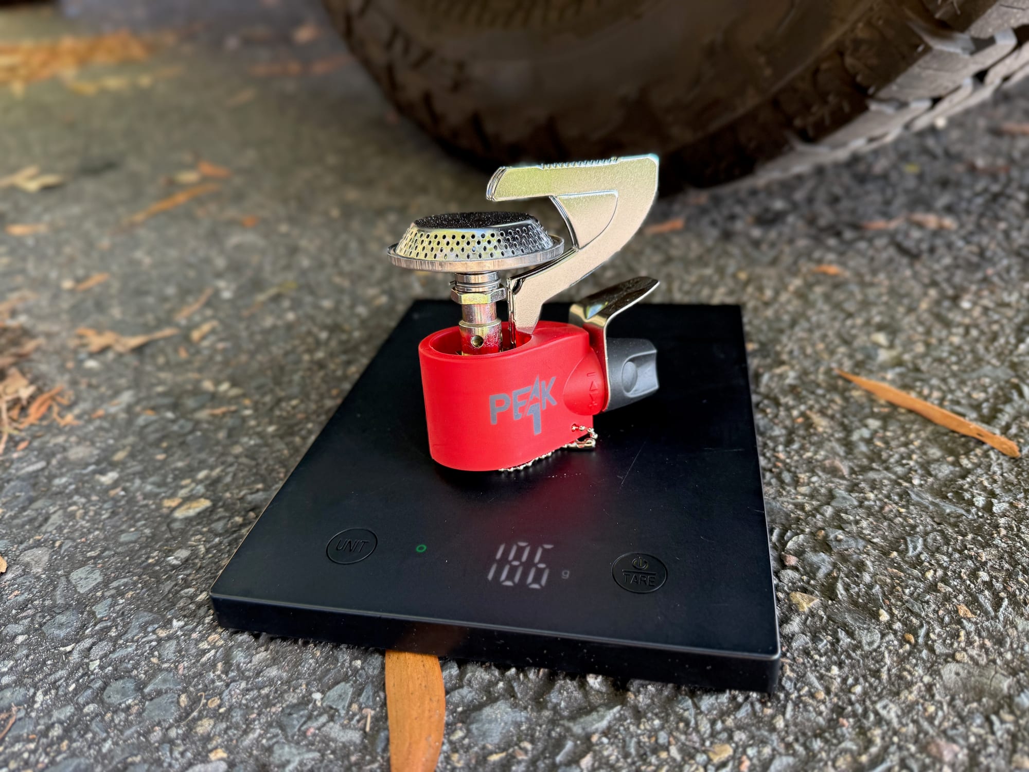 The Coleman Peak 1 stove on a kitchen scale showing 186 g