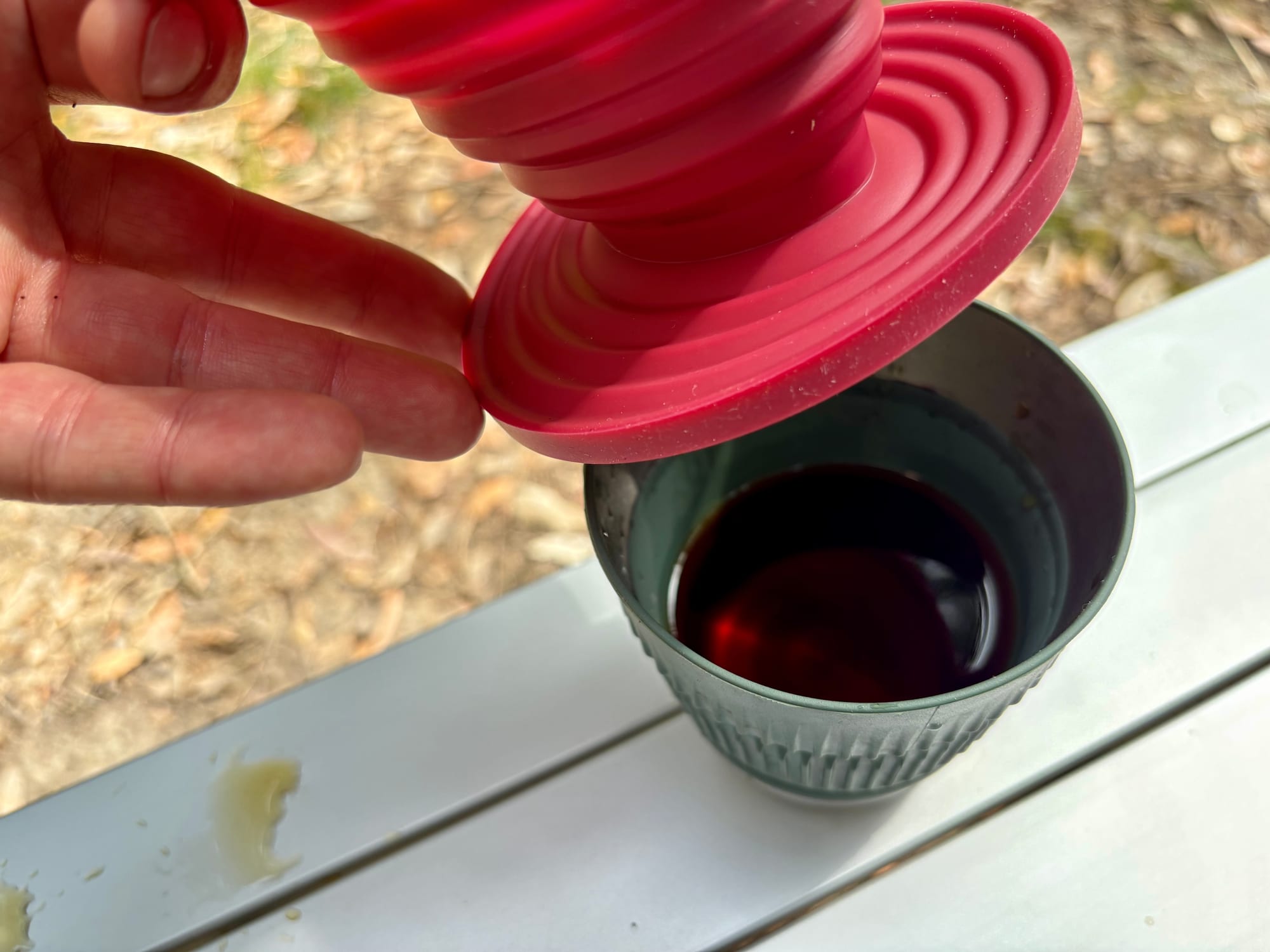 The brewed coffee in the mug, with the dripper lifted off