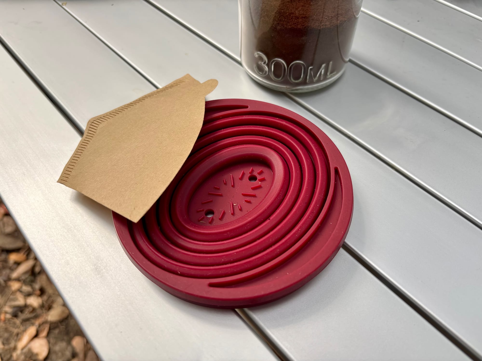 The collapsible coffee dripper folded flat, with a paper cone filter