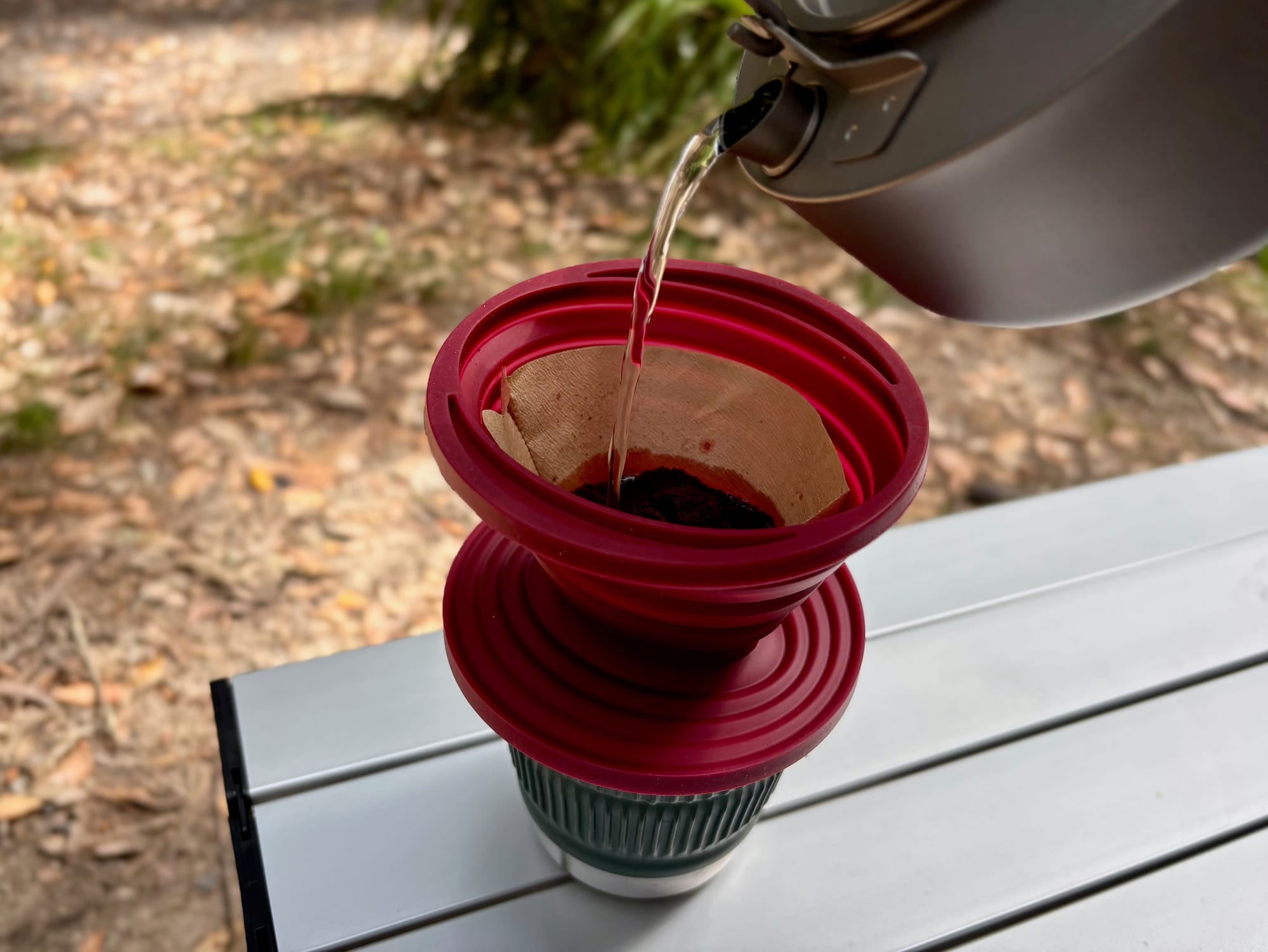 Pouring hot water from a kettle over the coffee in the dripper