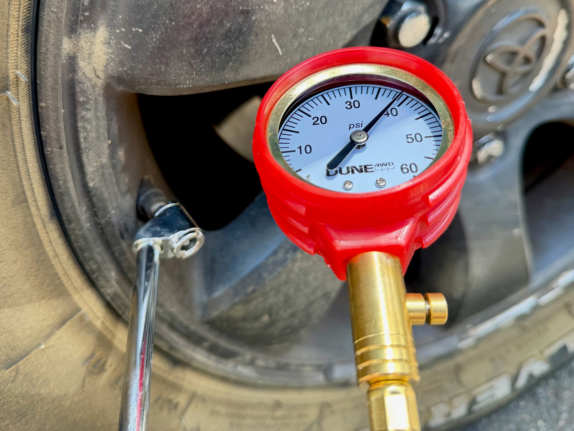 The dial of the Dune 4WD Tyre Pressure Gauge reading just under 40 PSI in front of a 4WD wheel