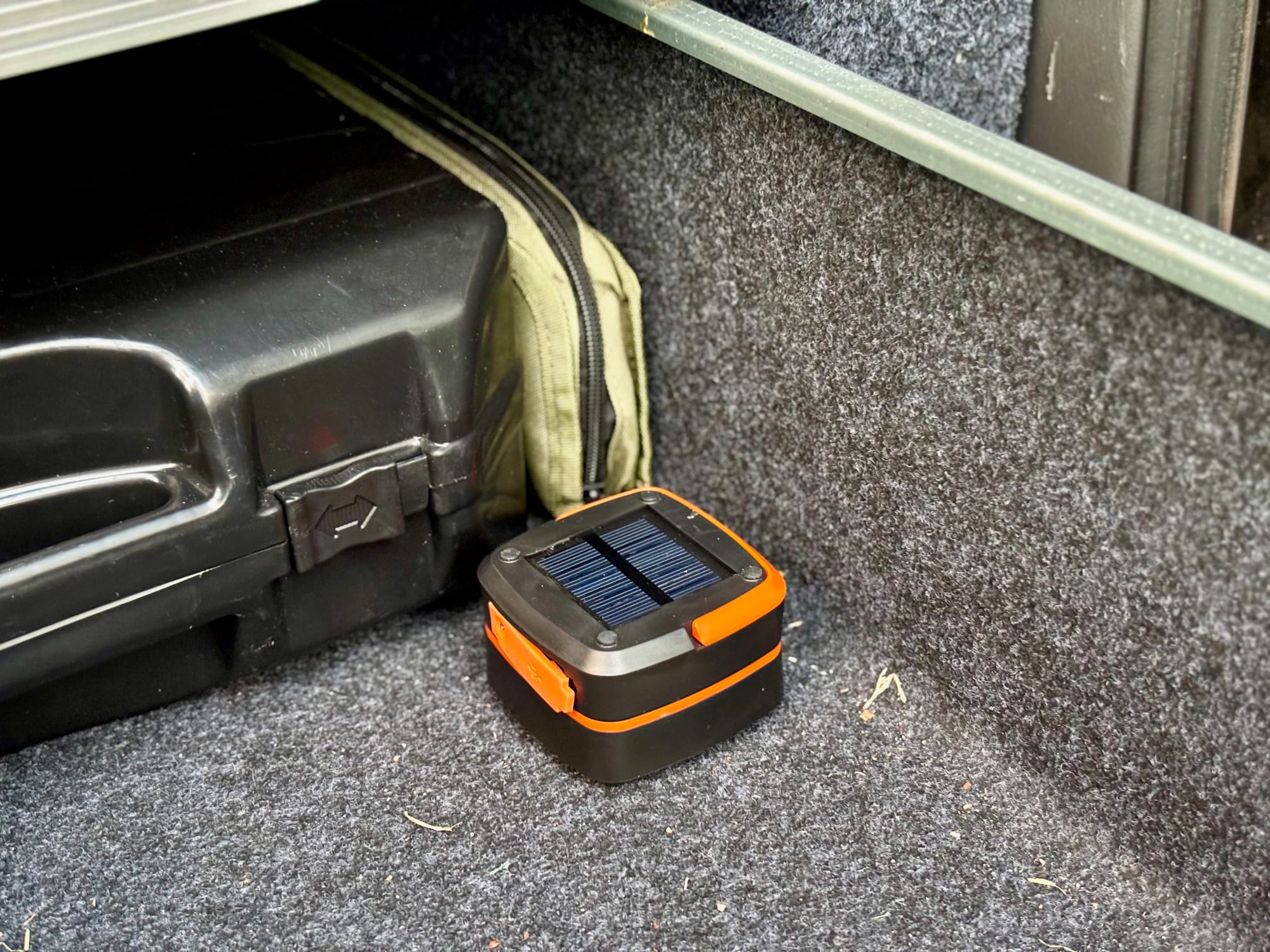 The folded solar lantern in the boot of the car, next to a storage case