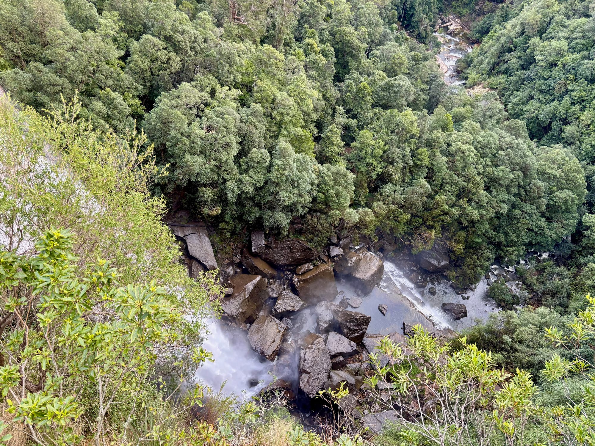 Looking straight down from the lookout at the water hitting the boulders at the foot of Fitzroy Falls